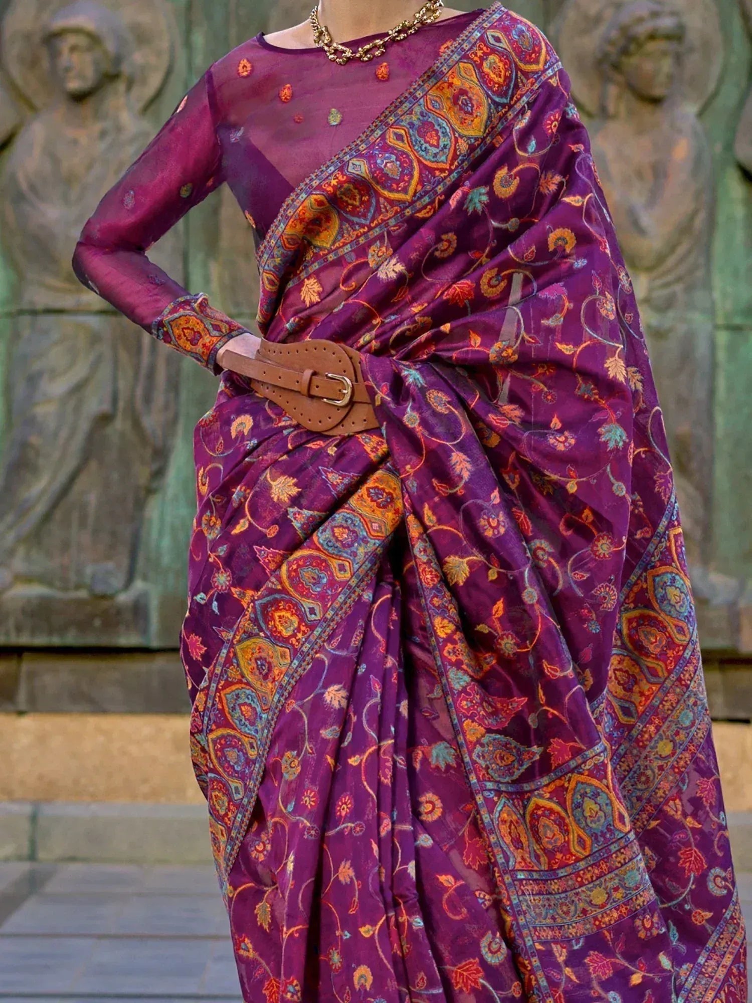 Purple printed saree with floral paisley design, styled with belt and gold necklace for ethnic wear