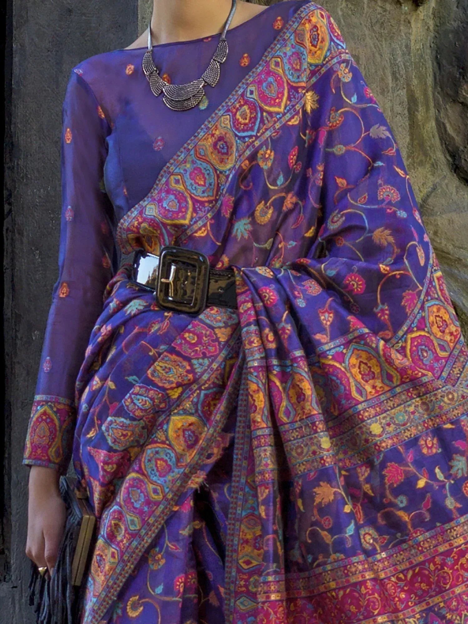 Purple ethnic saree with vibrant paisley print, styled with belt and statement necklace for modern Indian wear