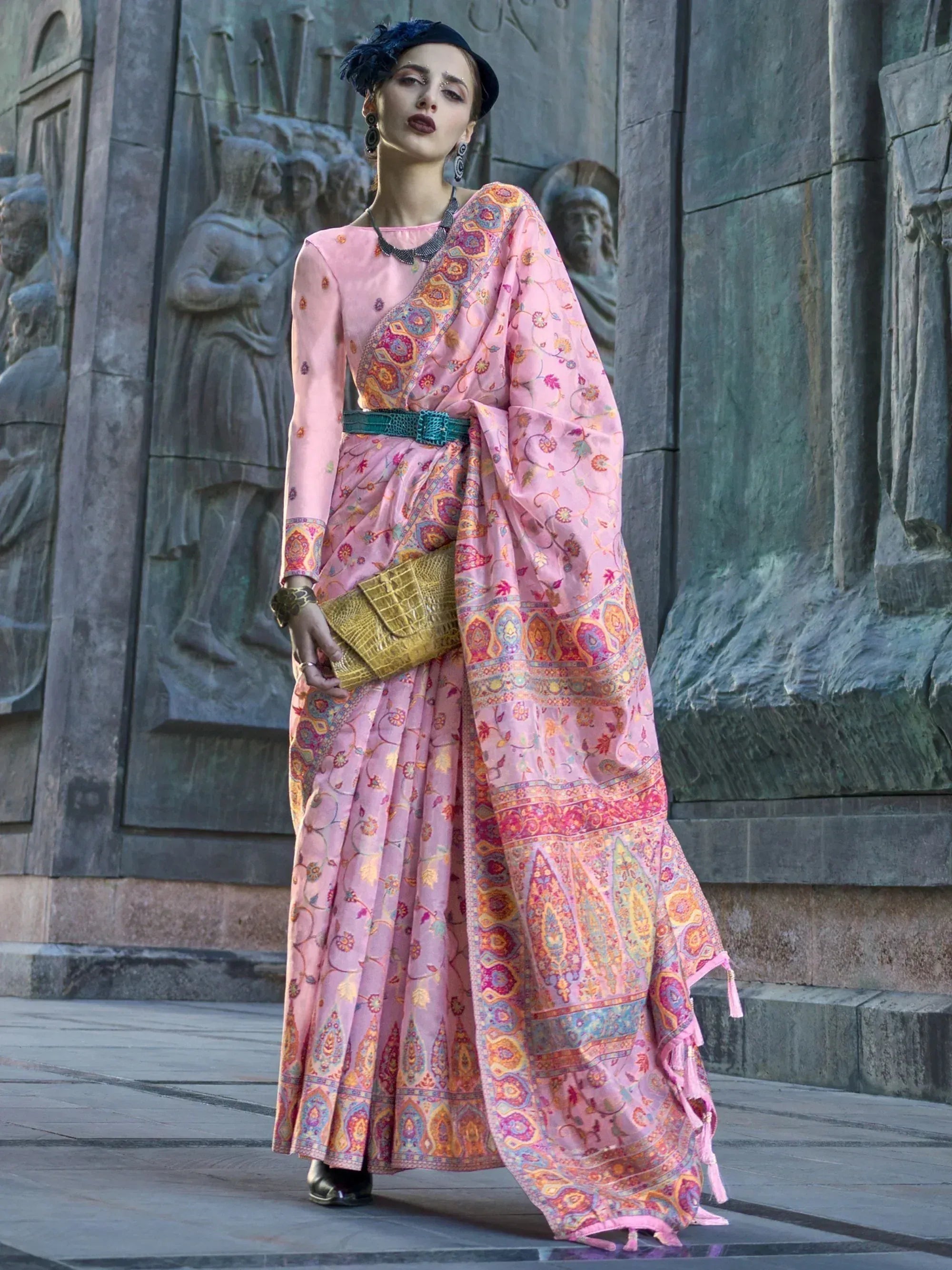 Pink printed ethnic saree with belt, styled with hat and clutch for modern Indian fashion