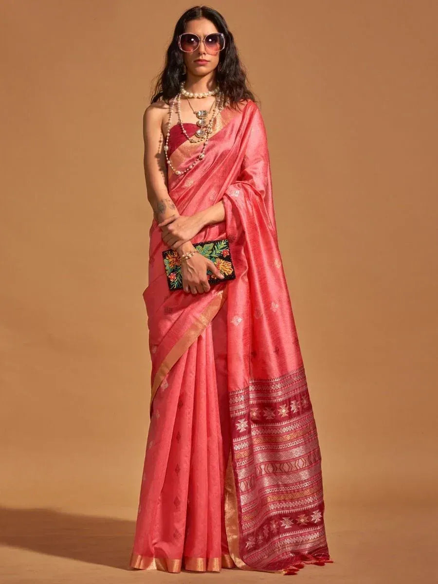 Elegant pink saree with intricate border designs, paired with pearl jewelry and floral clutch