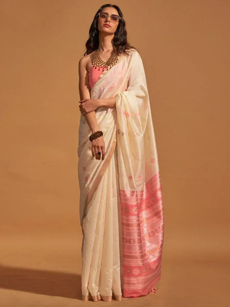 Cream and pink designer saree with floral motifs and woven border, paired with statement jewelry