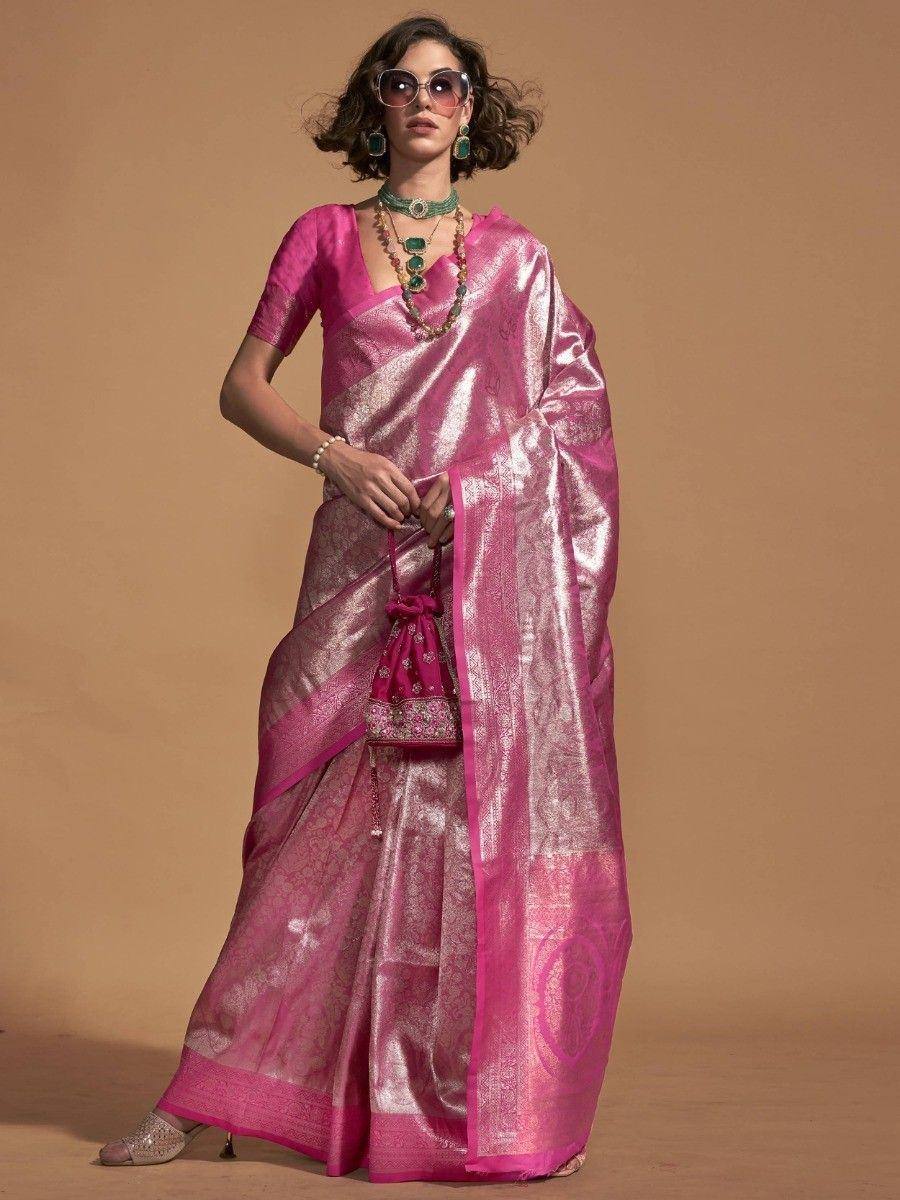 Pink designer saree with gold zari work, paired with matching blouse and ethnic jewelry for festive occasions