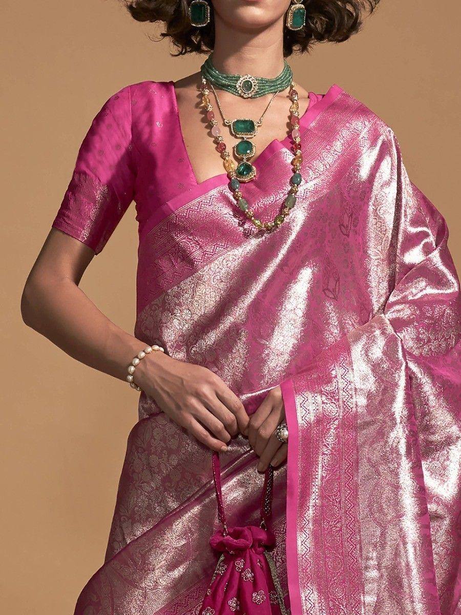 Pink silk saree with gold zari work, paired with emerald jewelry and pearl bracelet for ethnic wear