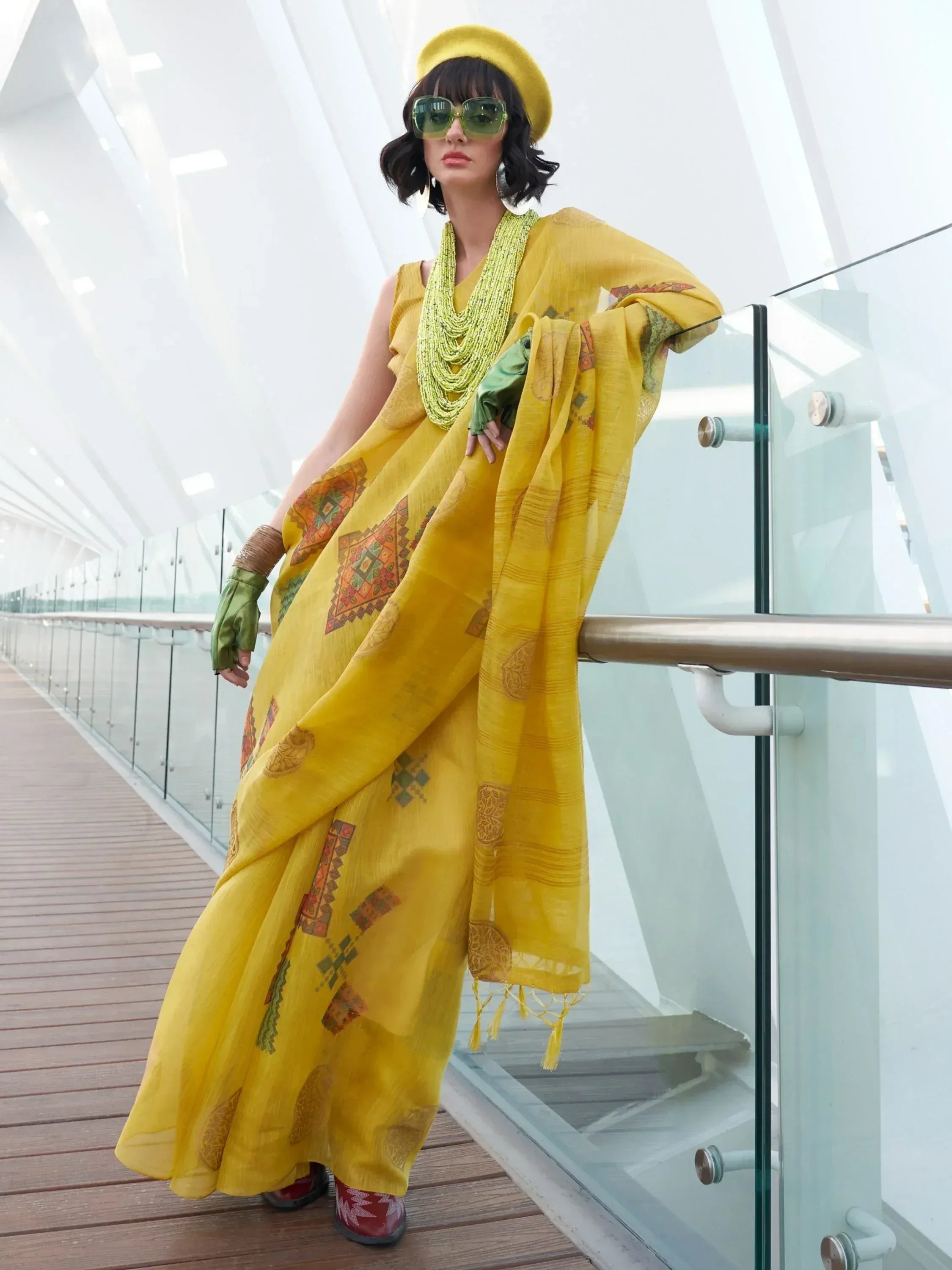 Yellow ethnic gown with geometric print, paired with matching dupatta and green accessories for modern Indian wear