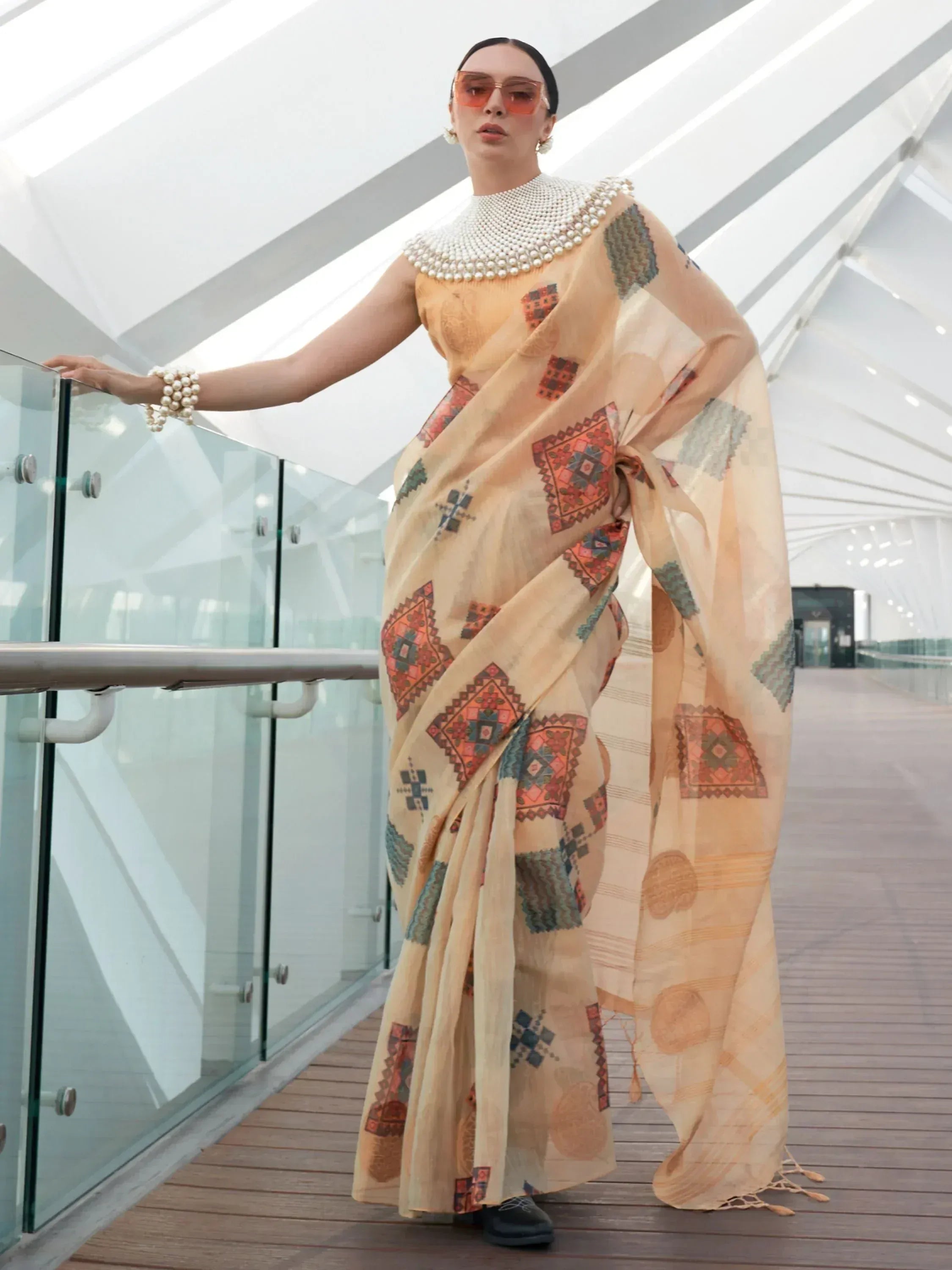 Woman in beige printed saree with pearl embellished blouse, modern ethnic wear