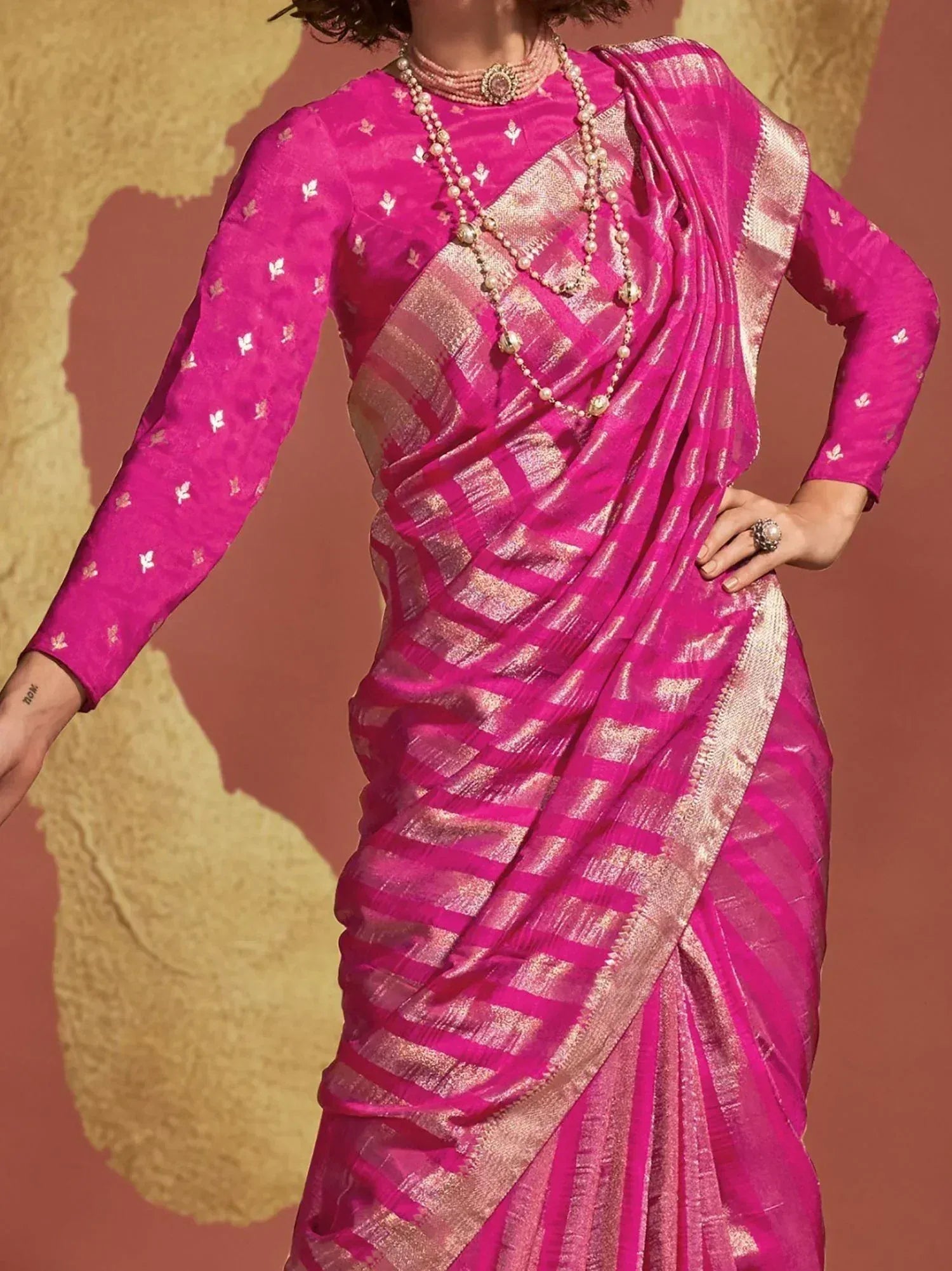 Vibrant pink ethnic saree with gold checks, paired with embroidered blouse and pearl jewelry