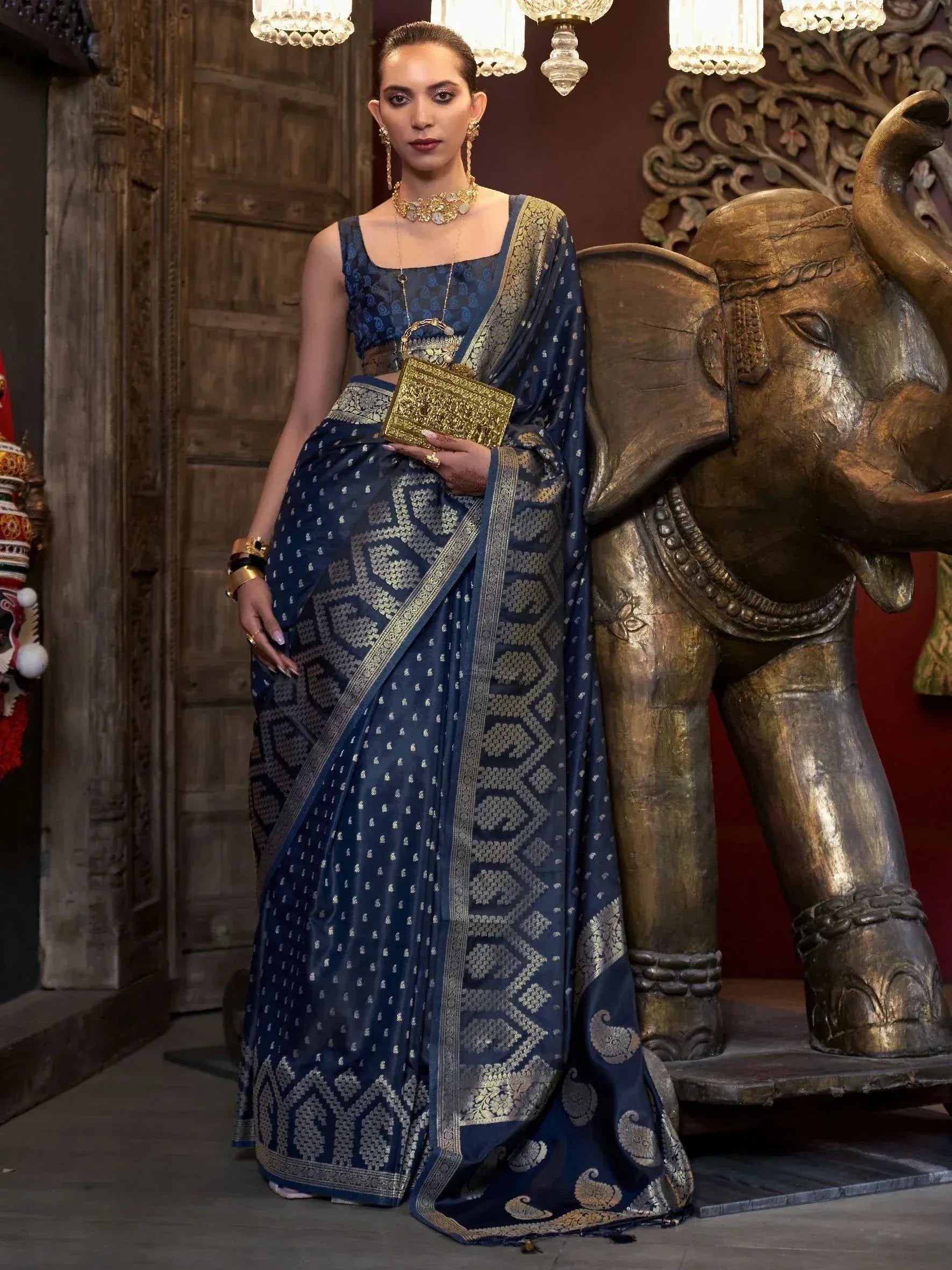 Elegant navy blue saree with gold embroidery, paired with statement jewelry, perfect for Indian ethnic occasions.