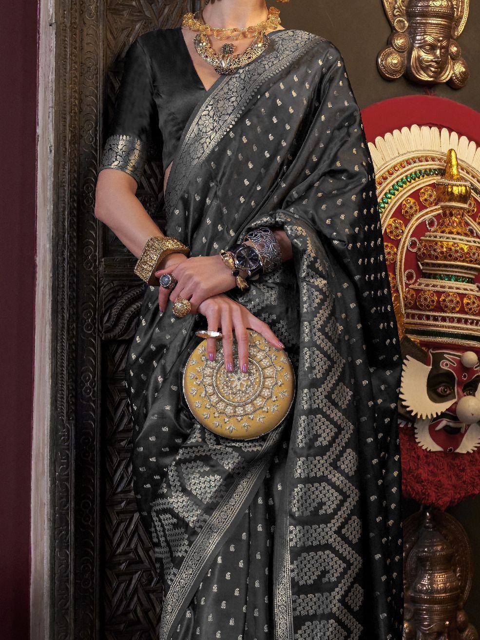 Black and gold embroidered saree with matching blouse, traditional jewelry, and ornate clutch for Indian ethnic wear