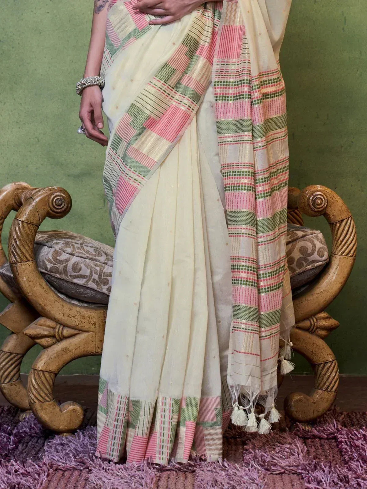 Cream saree with pink and green geometric border, tassels, styled for ethnic wear
