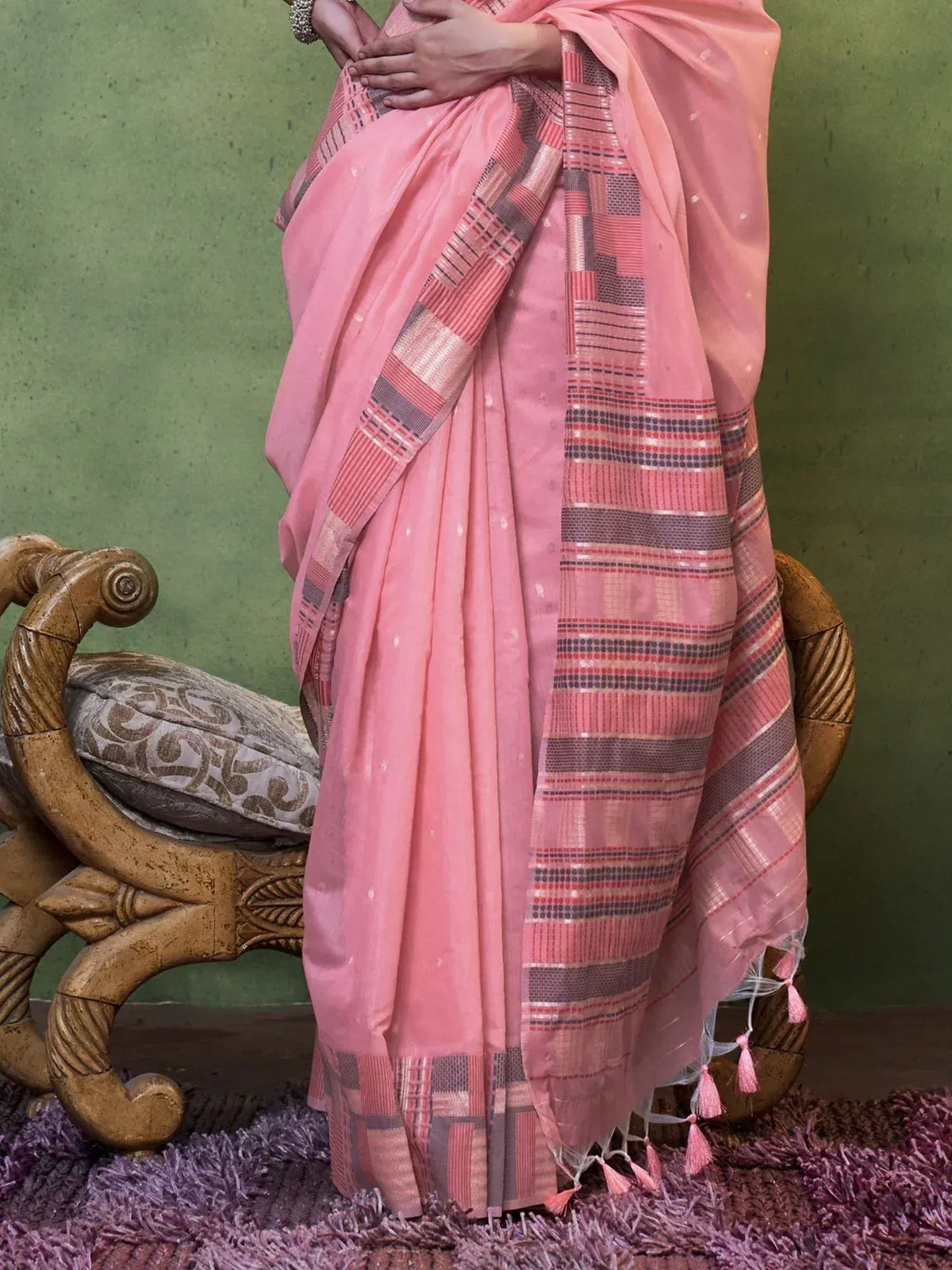 Pink ethnic saree with geometric border and tassels, styled for traditional Indian wear