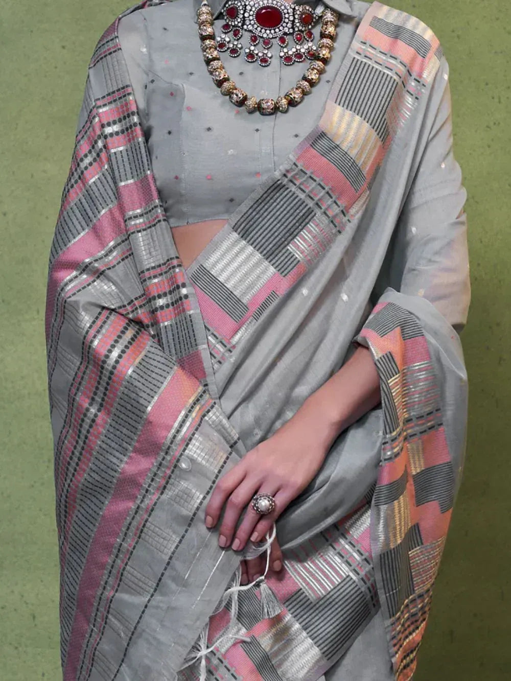 Grey saree with pink and silver geometric border, paired with statement necklace for ethnic wear