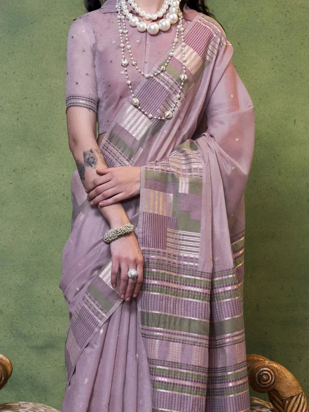 Lavender ethnic saree with geometric border, paired with pearl jewelry for traditional Indian wear