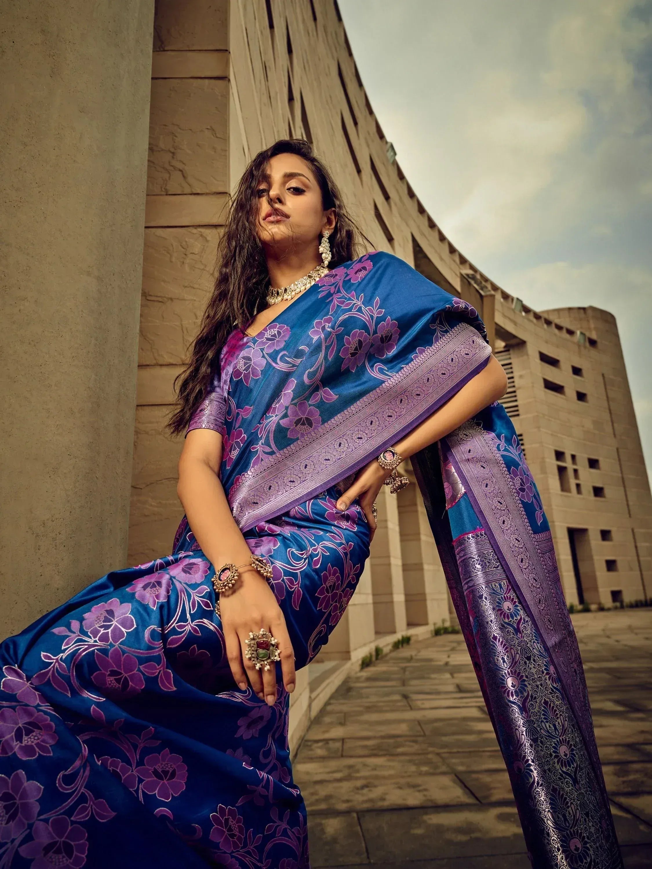 Blue and purple floral saree with intricate border, styled with traditional jewelry for ethnic wear