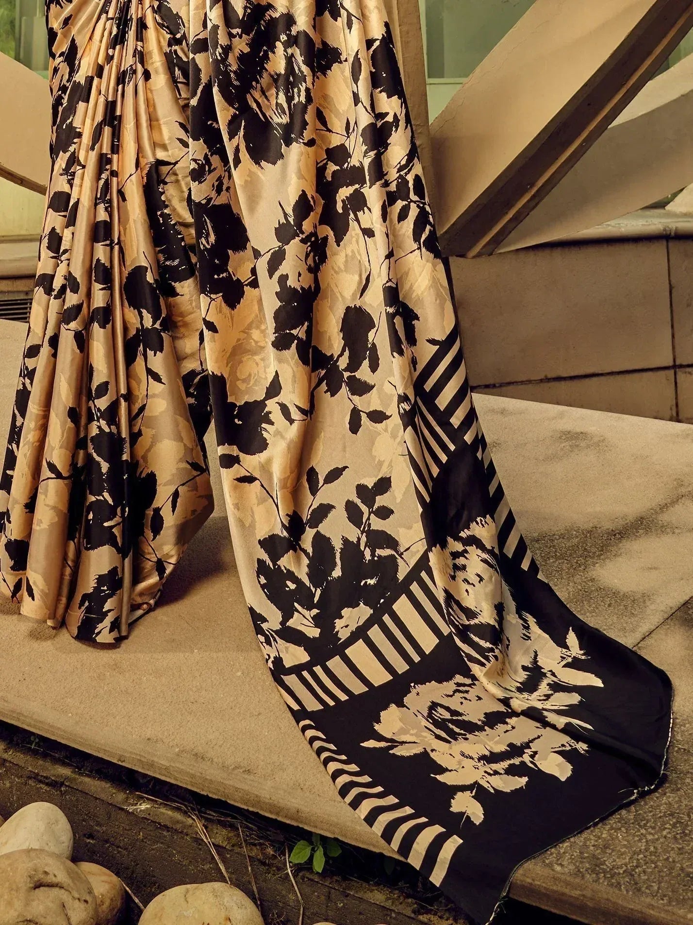 Black and gold floral print saree with striped border, elegant ethnic wear for women