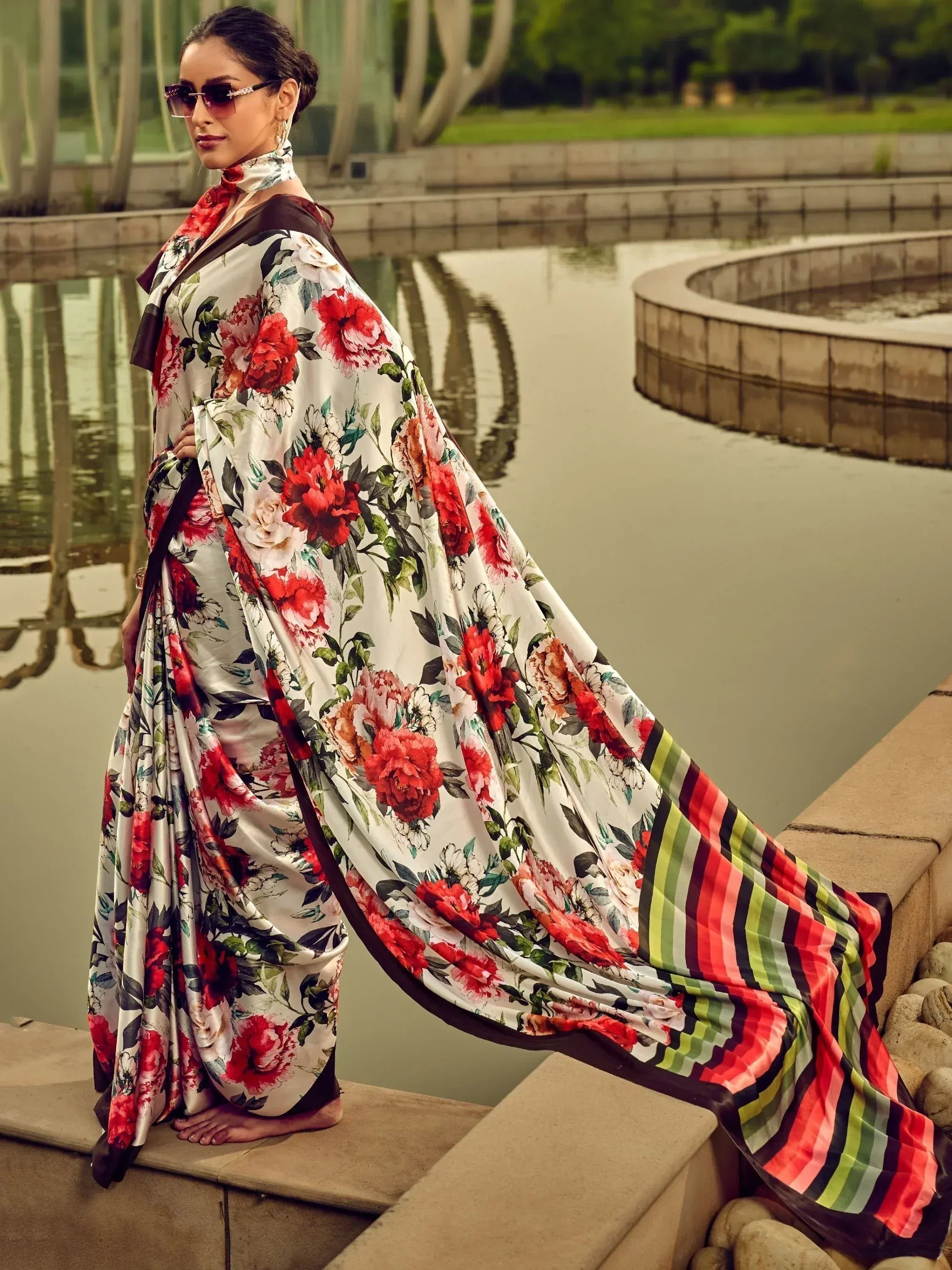 Floral print saree with red roses and striped border, styled for ethnic wear