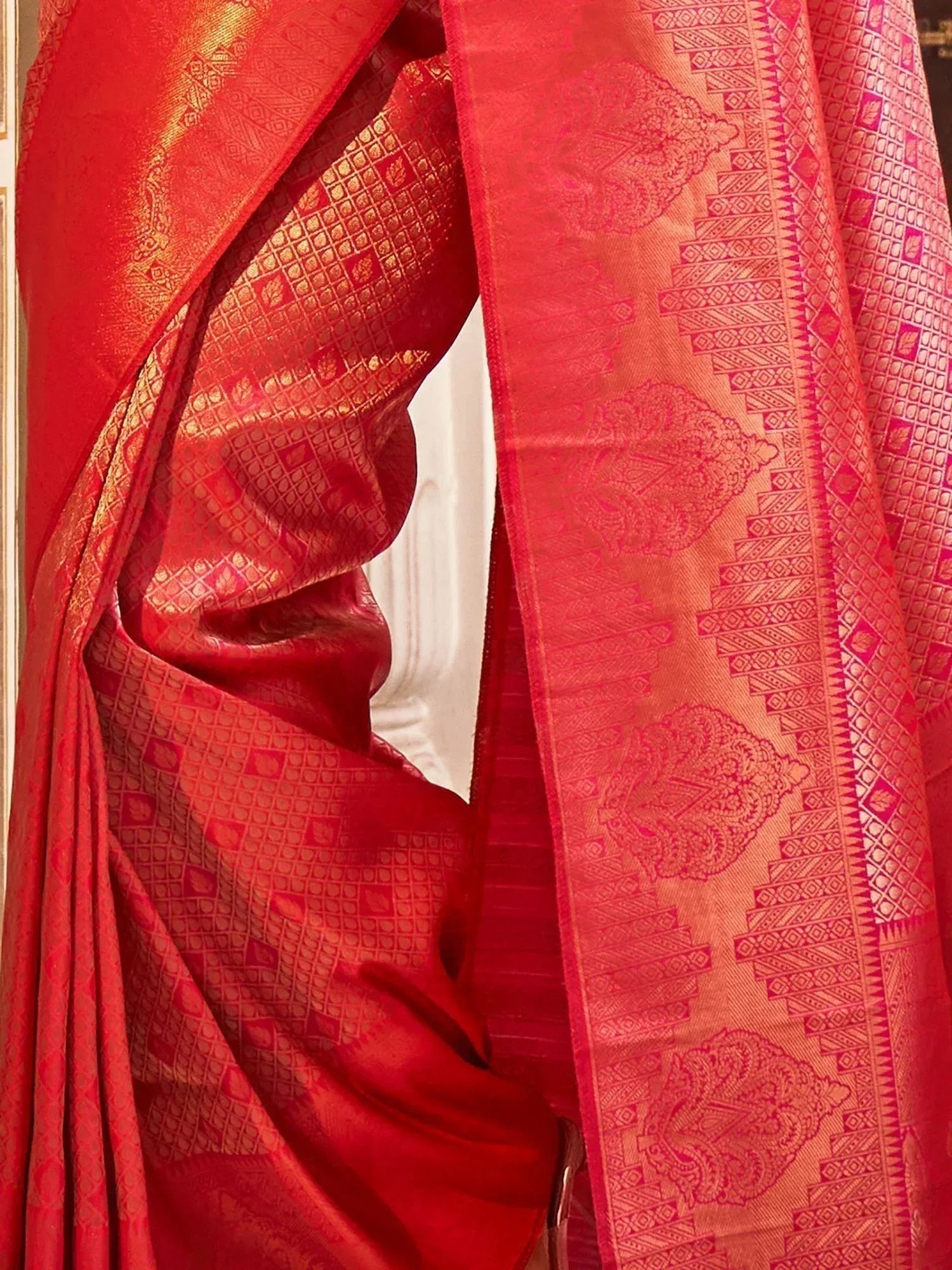 Red designer saree with gold woven patterns and intricate border details, perfect for ethnic occasions