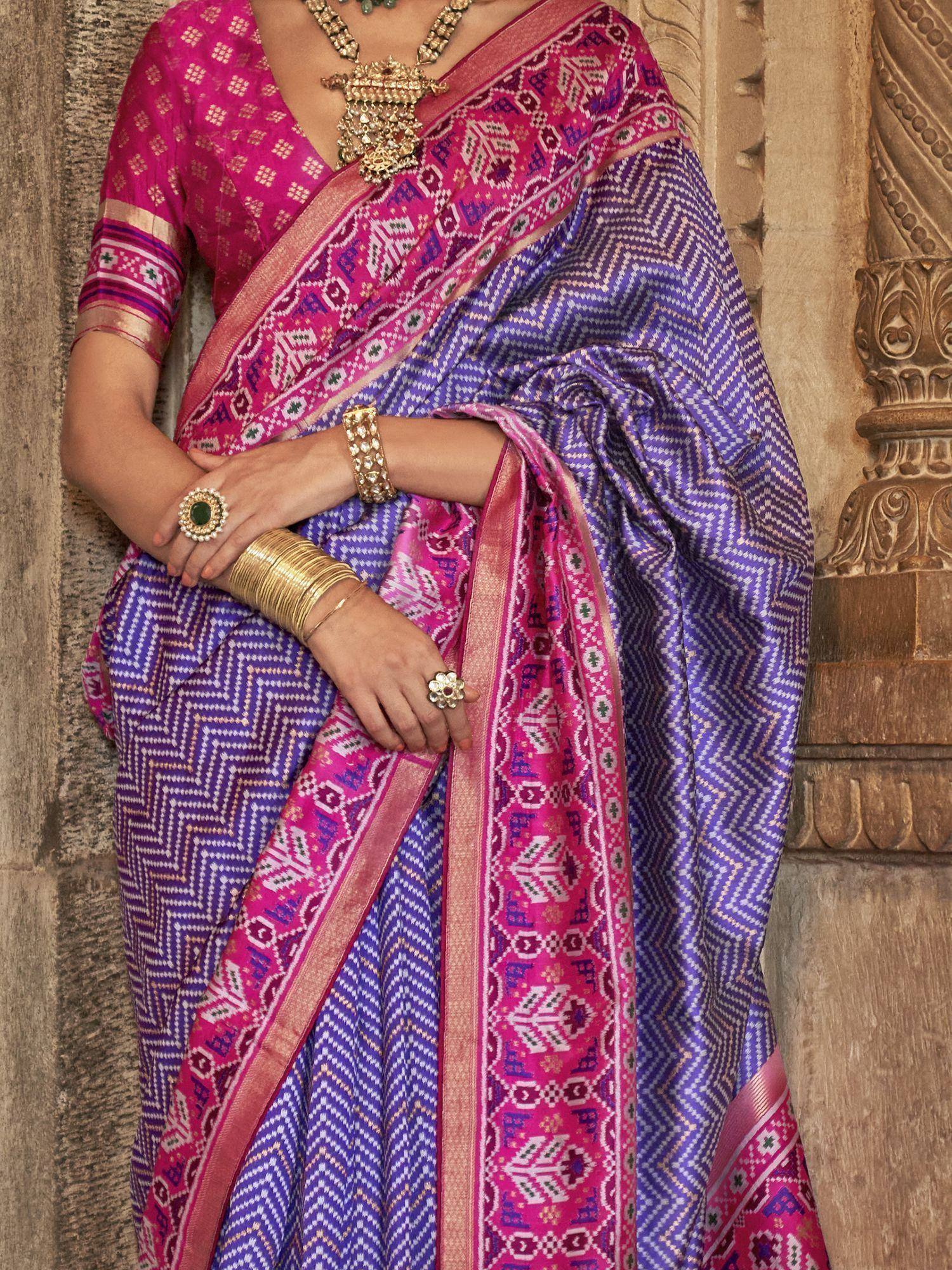 Vibrant purple and pink ethnic saree with geometric patterns, paired with traditional jewelry for festive occasions.