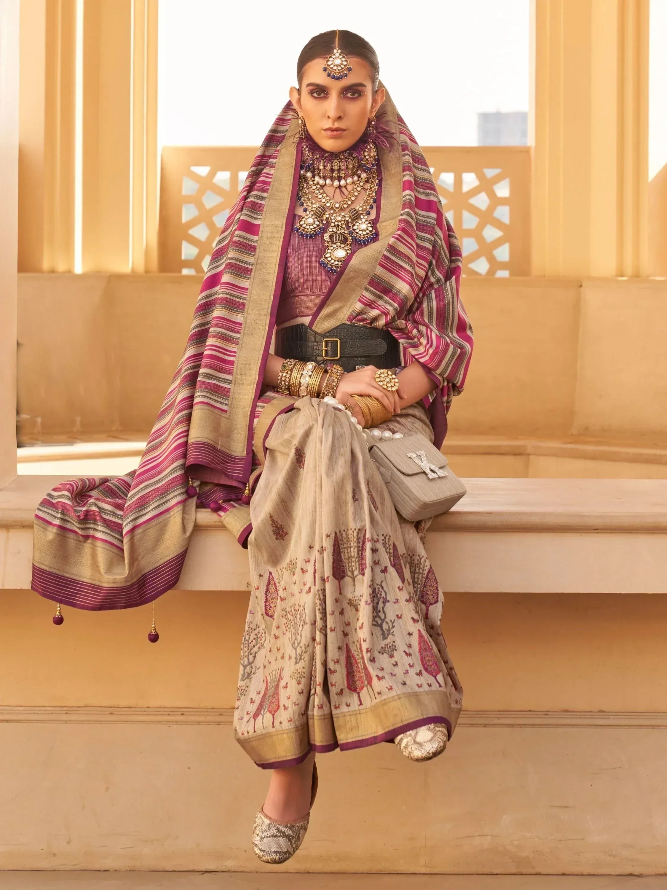 Woman in ethnic Indian outfit with printed skirt, striped dupatta, and traditional jewelry