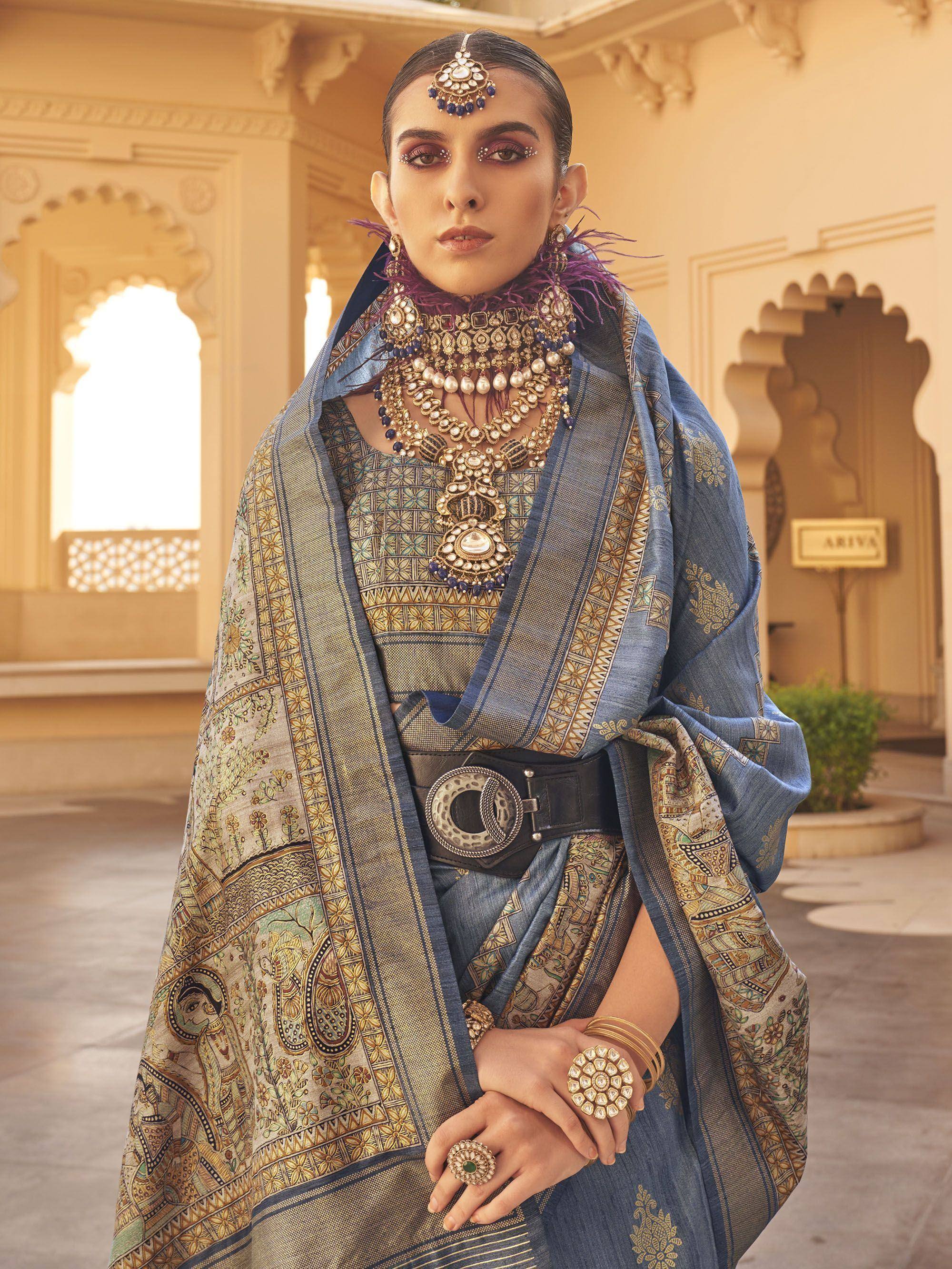 Blue printed ethnic saree with gold embroidery, statement jewelry, and traditional Indian bridal look