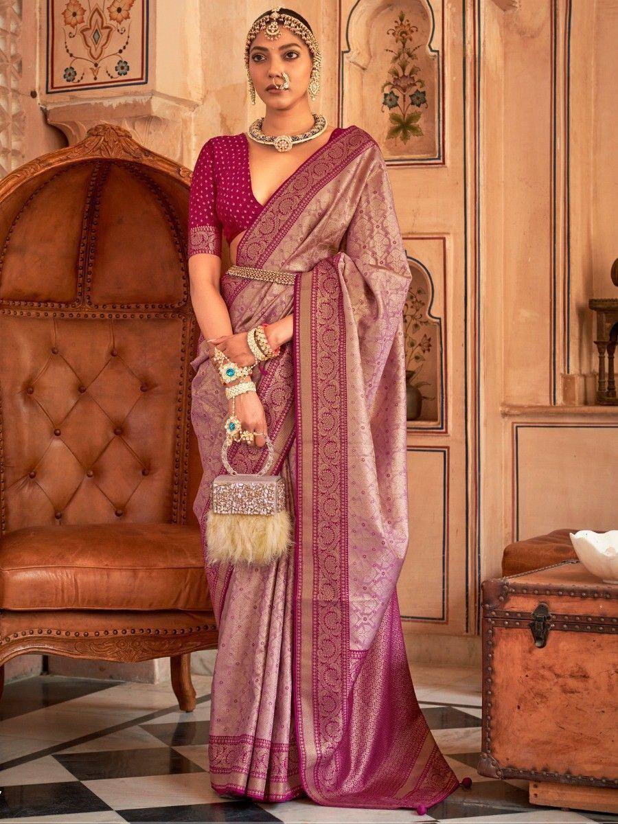 Elegant Indian saree in pink and gold with intricate embroidery, paired with traditional jewelry and a designer clutch.