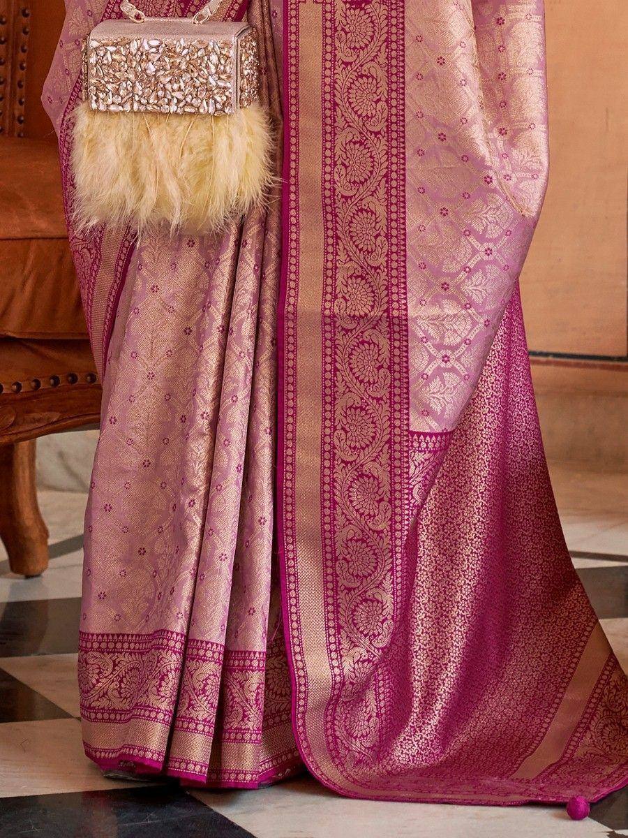 Pink and gold designer saree with intricate floral border and matching embellished clutch
