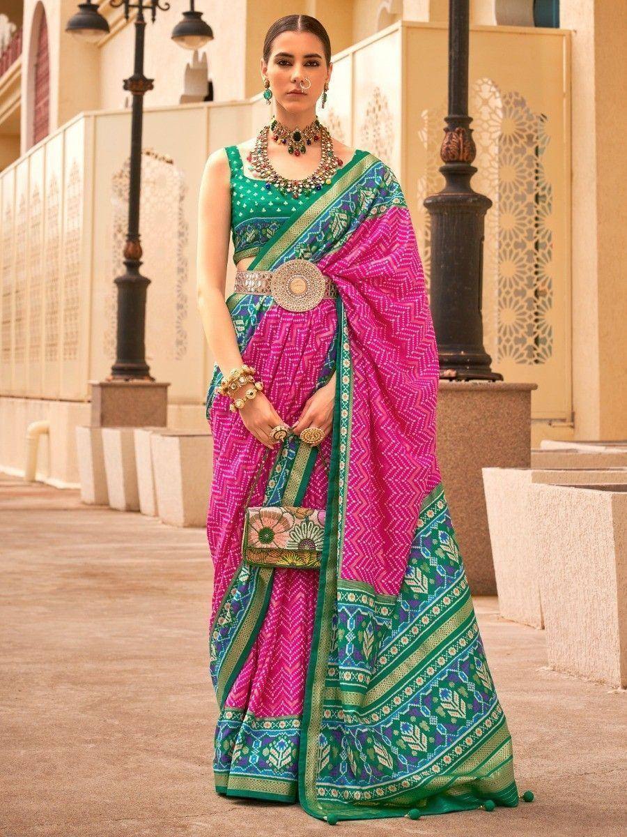Vibrant pink and green printed saree with ethnic jewelry, perfect for Indian festive occasions