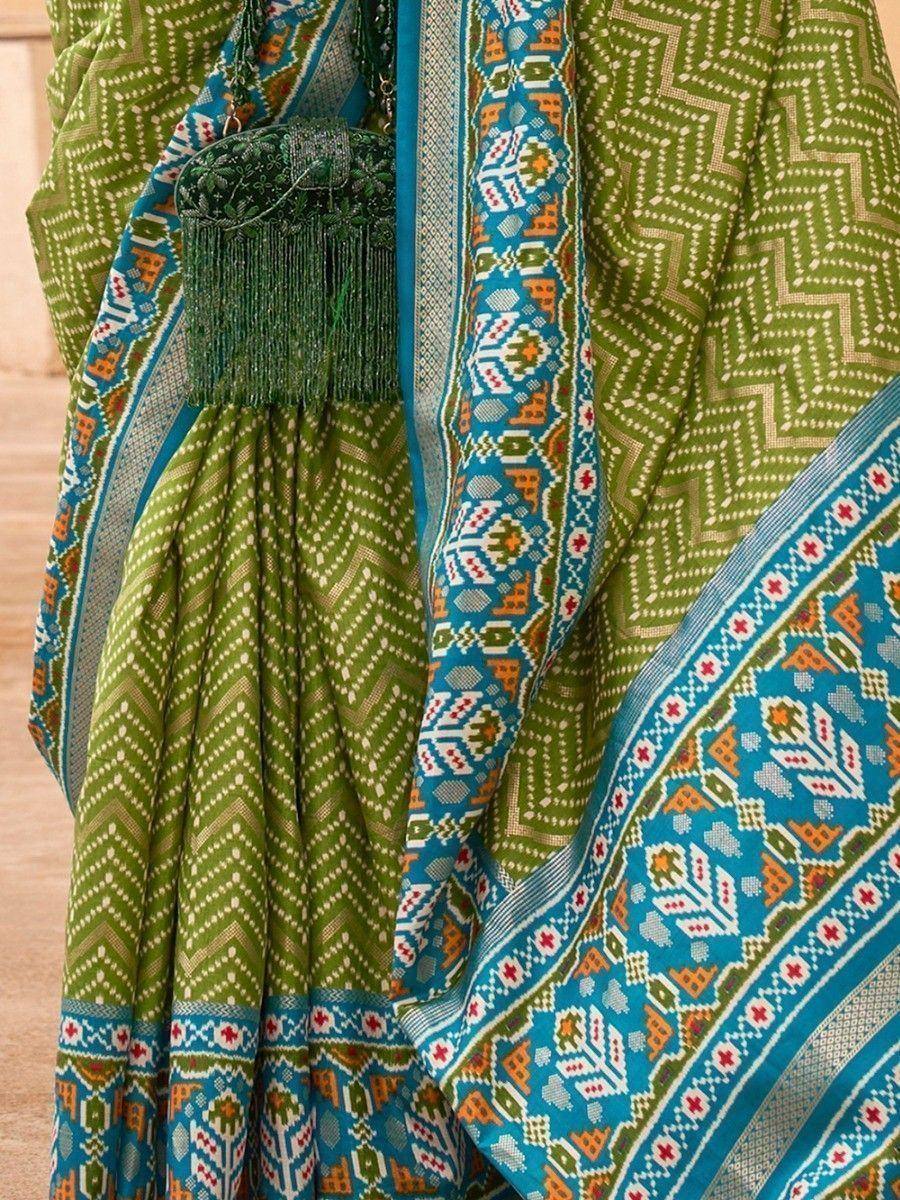 Green and blue ethnic saree with geometric patterns and tassel details, perfect for Indian festive wear.