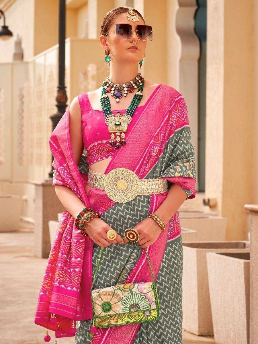 Pink and green ethnic saree with designer blouse, statement jewelry, and embroidered clutch for Indian wear