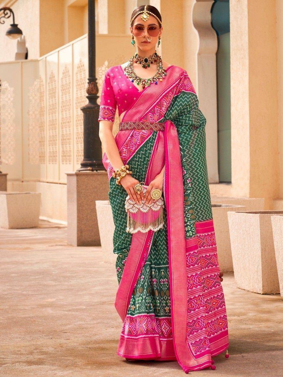 Pink and green ethnic saree with intricate patterns and traditional jewelry
