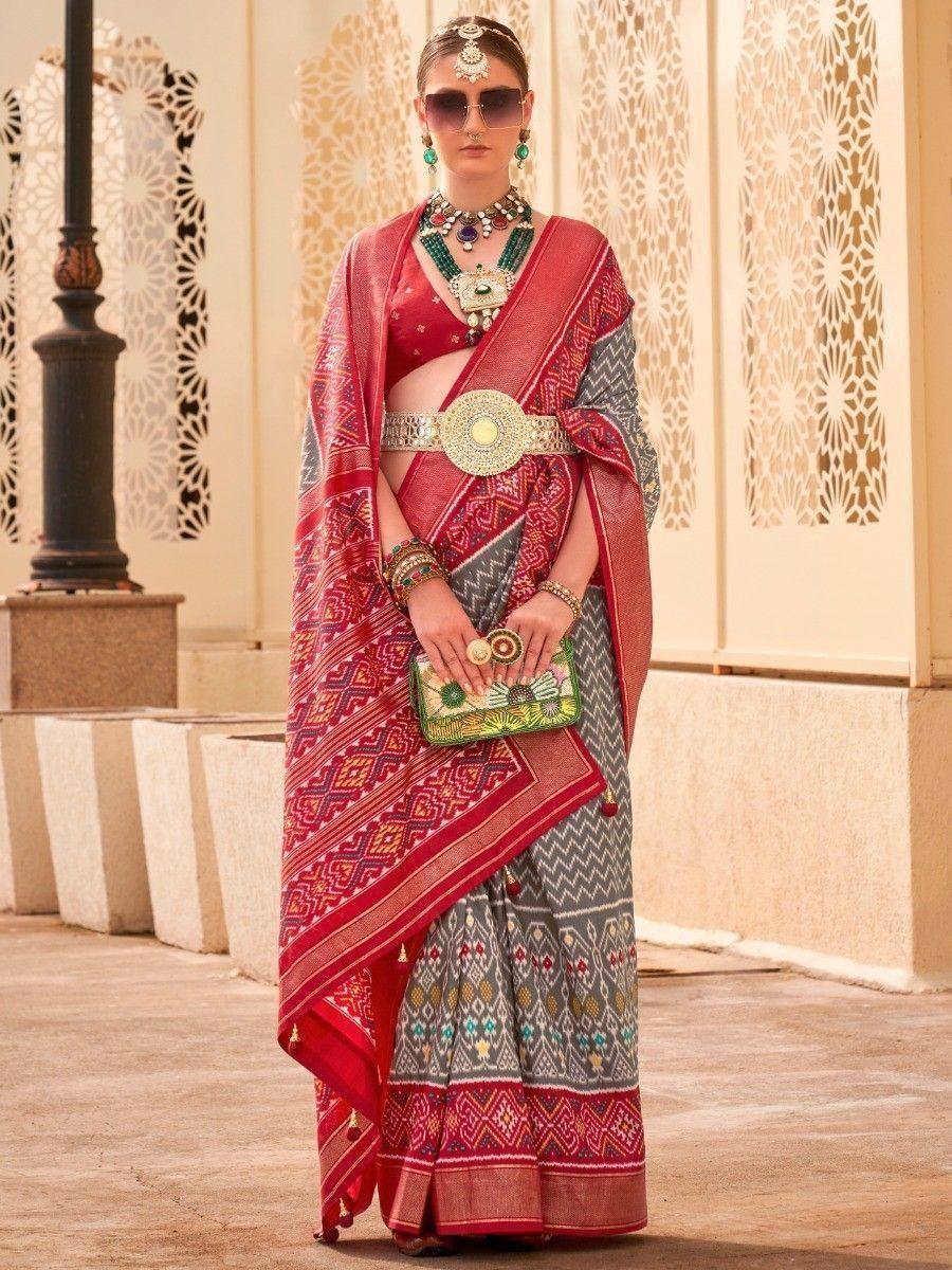 Red and grey printed saree with ethnic jewelry and statement belt, perfect for Indian festive occasions