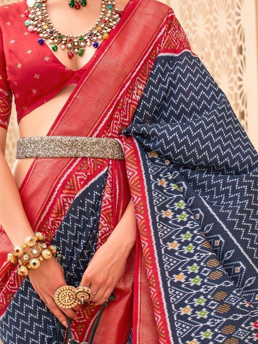 Red and navy blue ethnic saree with geometric patterns, paired with designer blouse and traditional jewelry