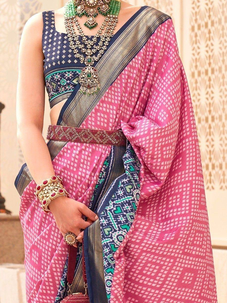 Pink printed saree with navy blue blouse, ethnic jewelry, and traditional Indian design