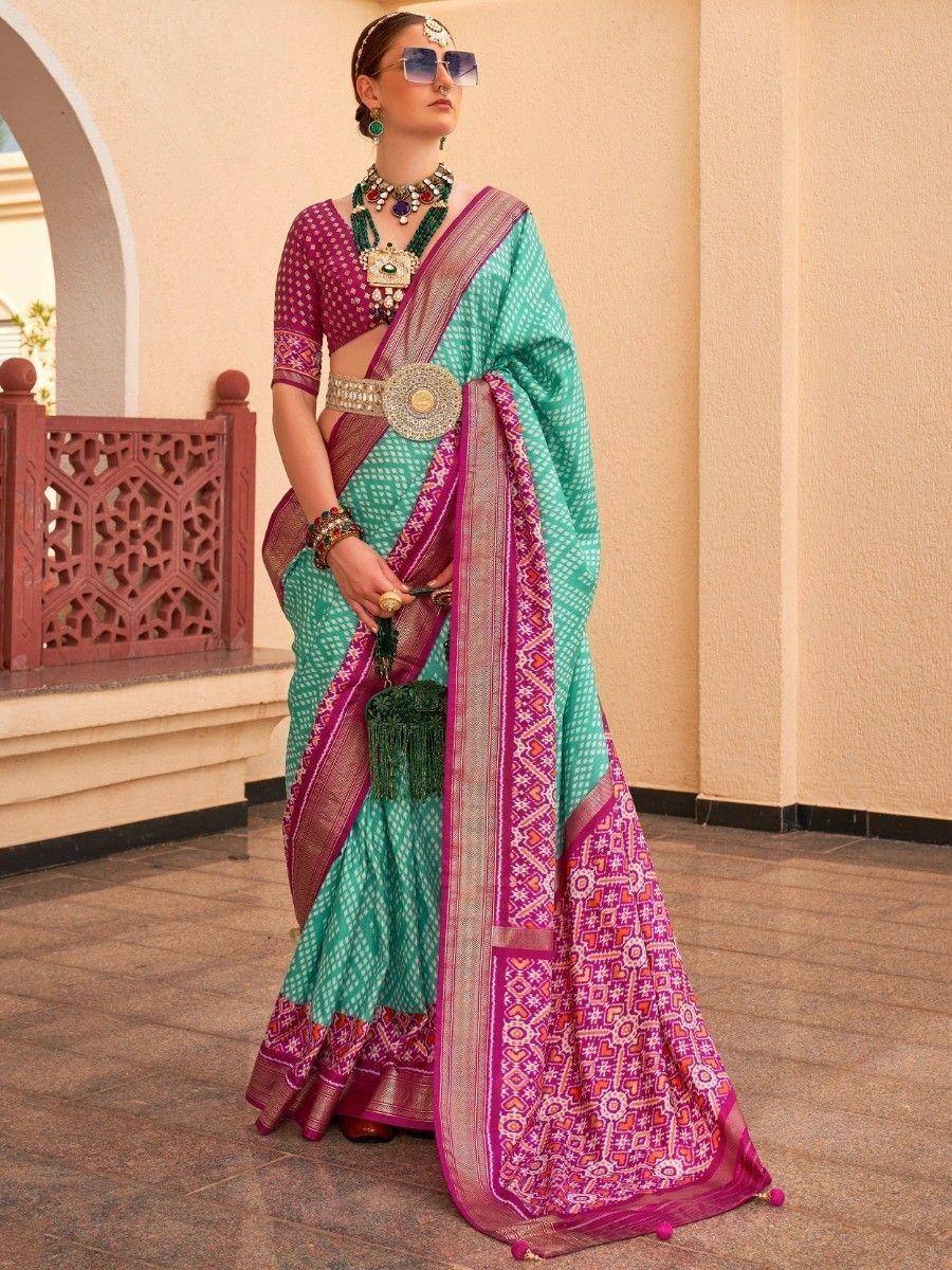 Teal and magenta ethnic saree with intricate patterns, paired with designer blouse and traditional jewelry