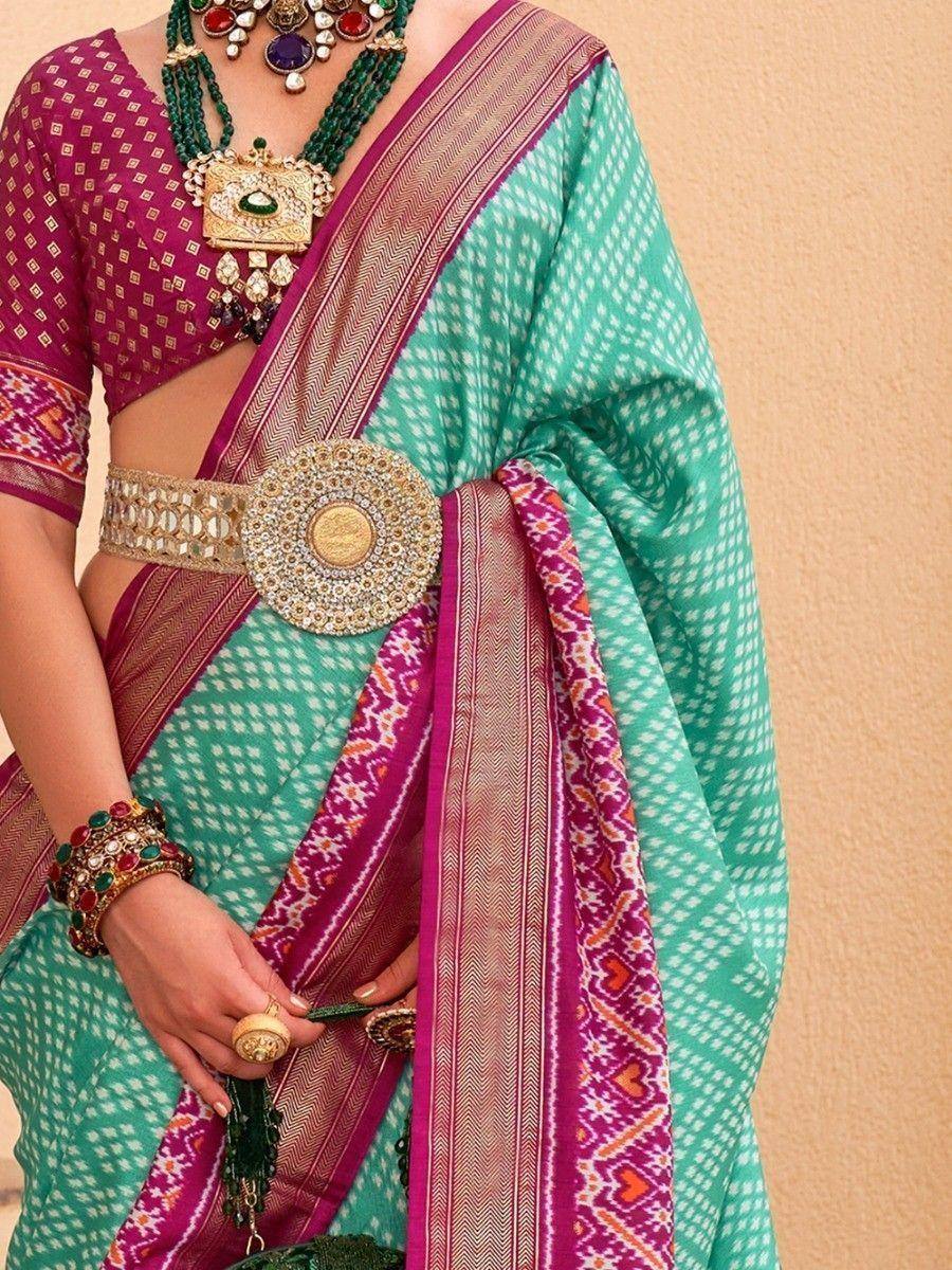 Turquoise and magenta ethnic saree with gold belt, traditional Indian jewelry, and patterned blouse