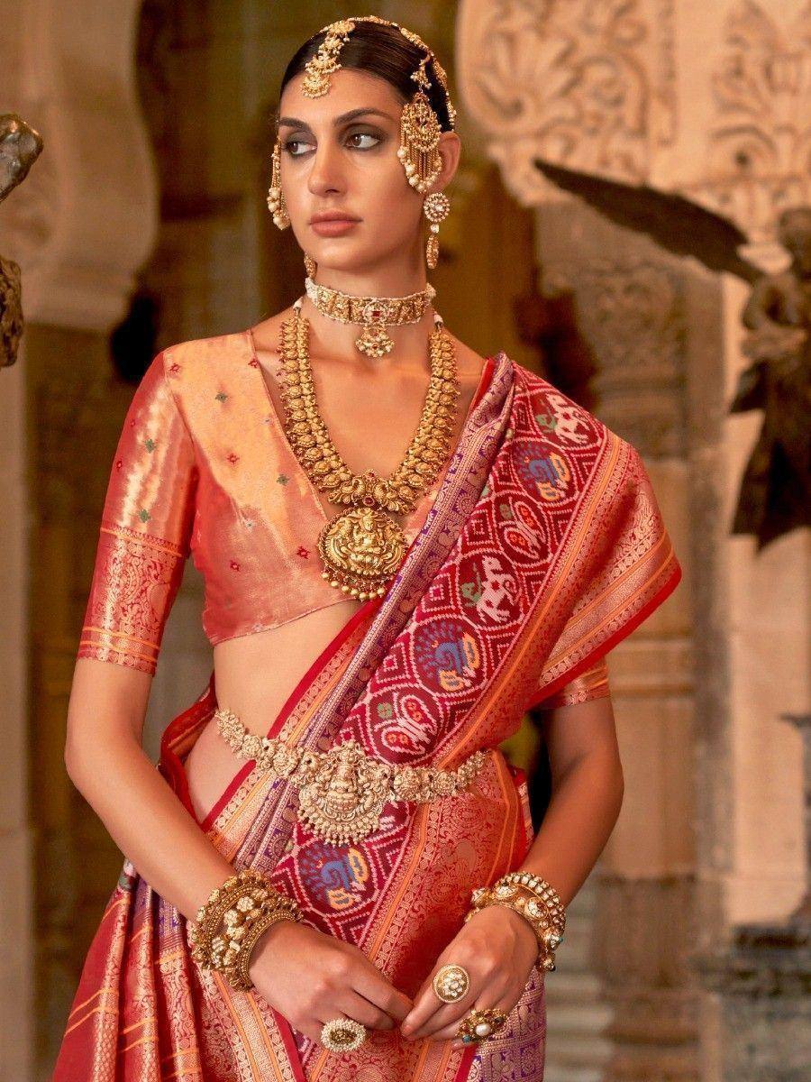 Elegant Indian bride in red and gold designer lehenga choli with intricate embroidery and traditional jewelry