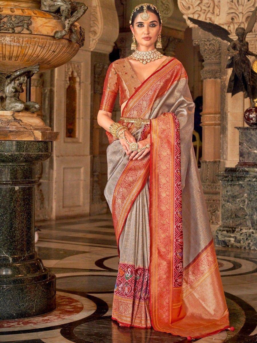 Elegant Indian saree with gold embroidery, red border, and traditional jewelry for festive occasions
