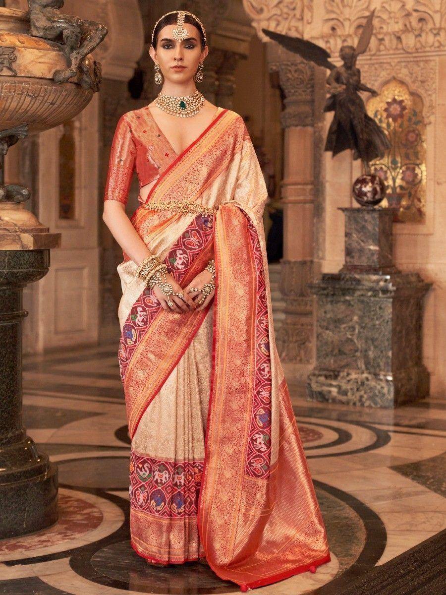 Elegant Indian saree with red and gold border, intricate embroidery, paired with designer blouse and traditional jewelry