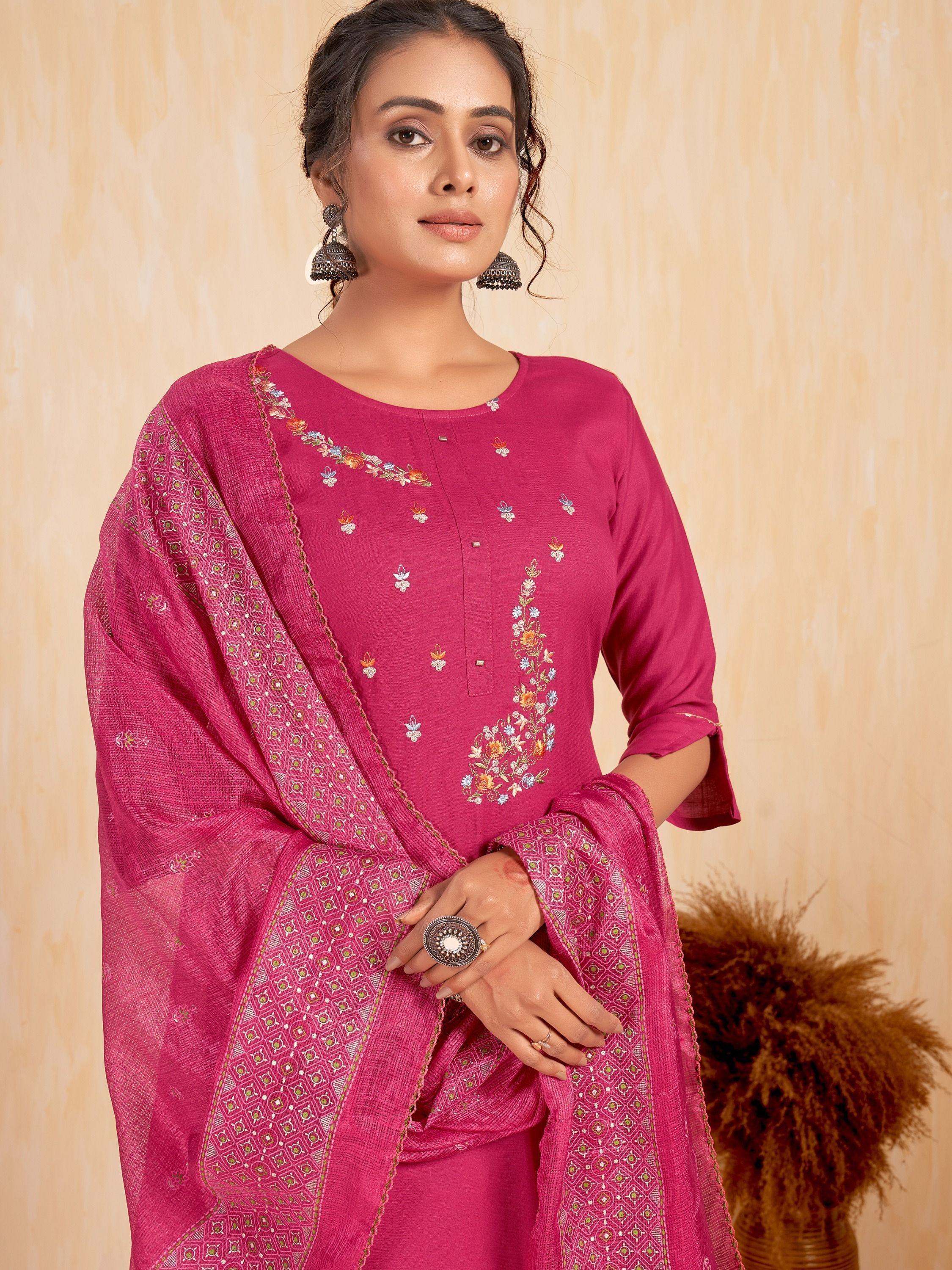 Woman wearing magenta embroidered salwar kameez with matching dupatta and oxidized jhumka earrings