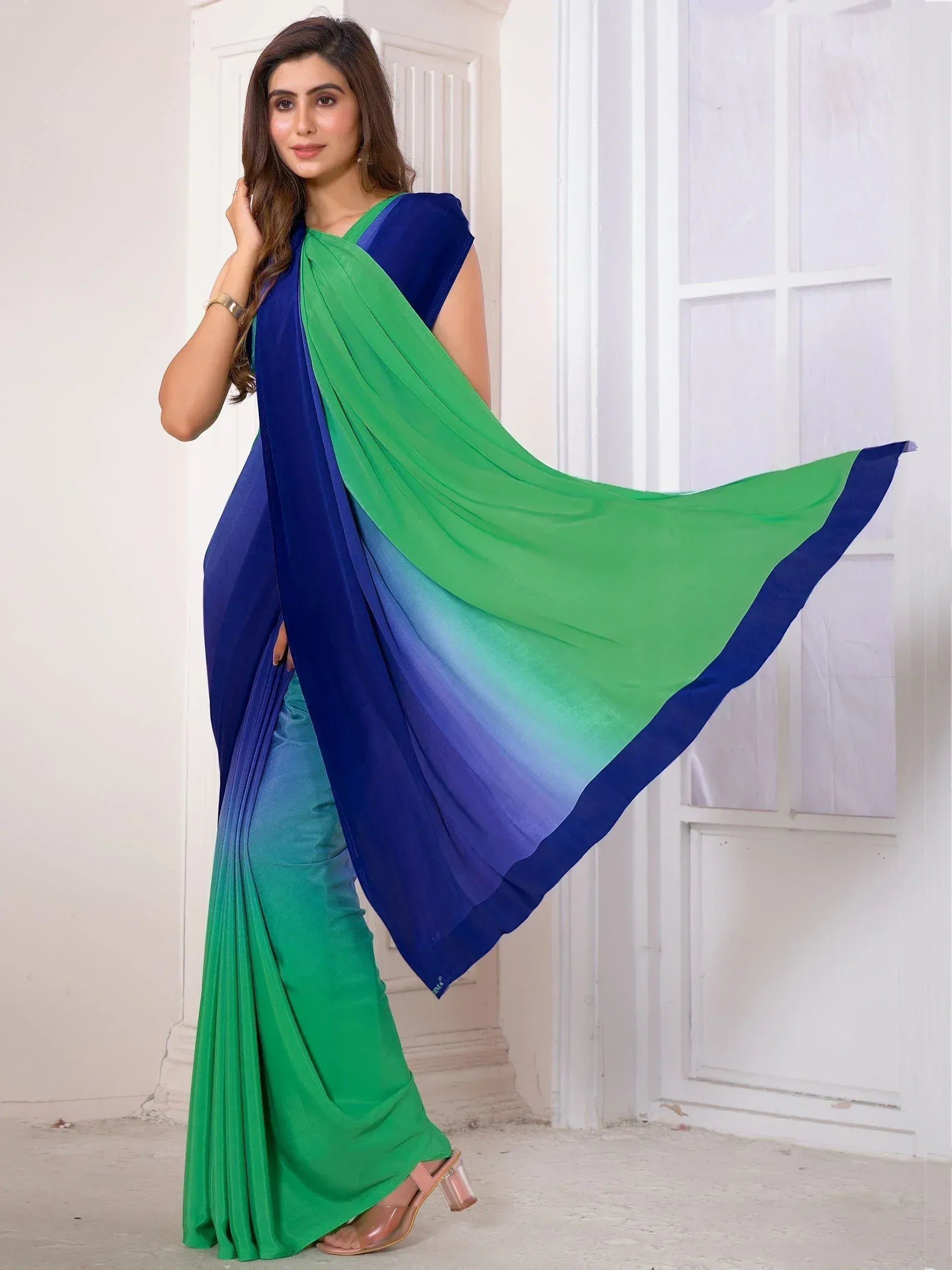 Woman in elegant green and blue ombre saree, stylish Indian ethnic wear for festive occasions