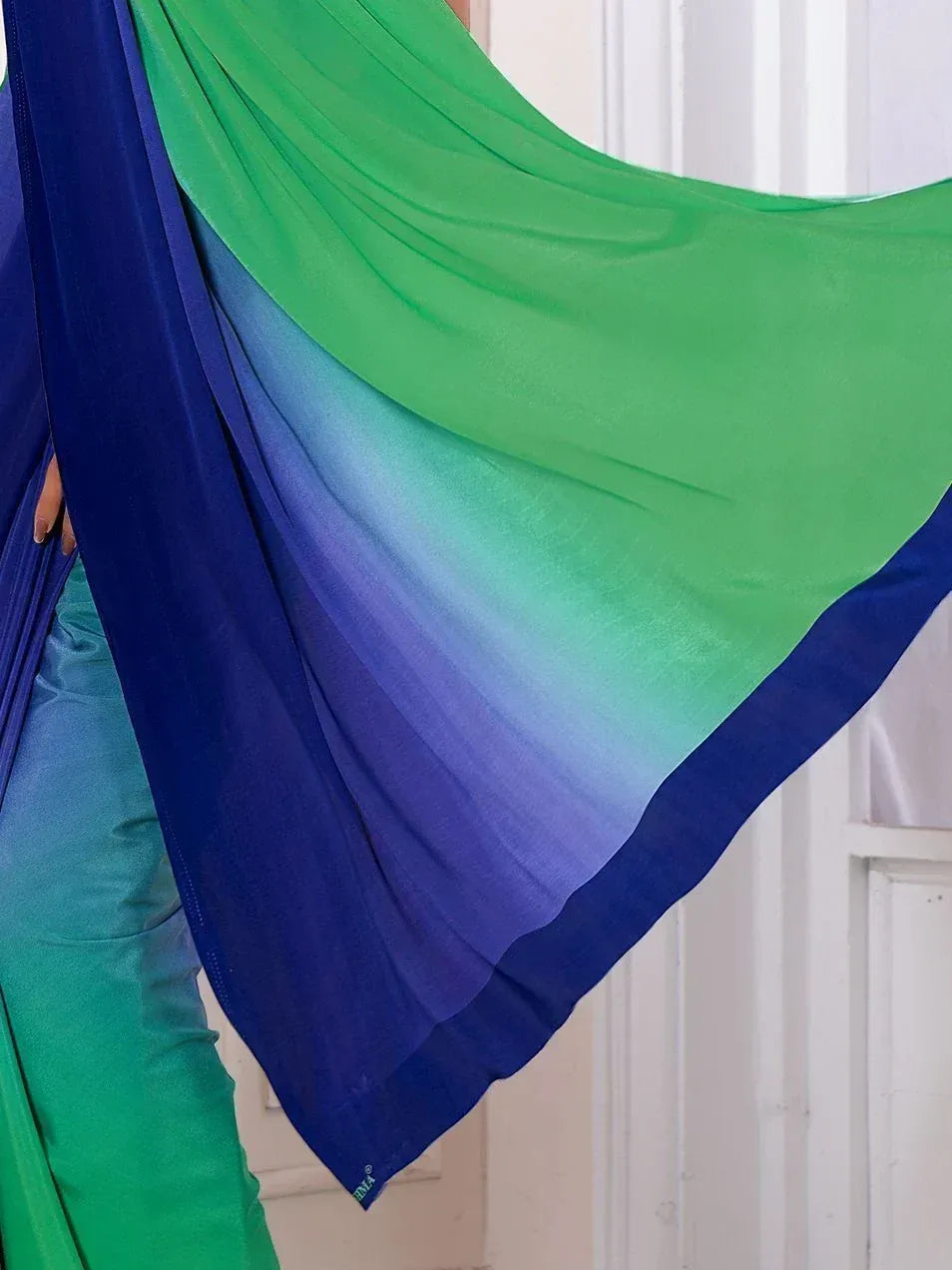 Green and blue ombre saree with flowing fabric, perfect for ethnic wear occasions.