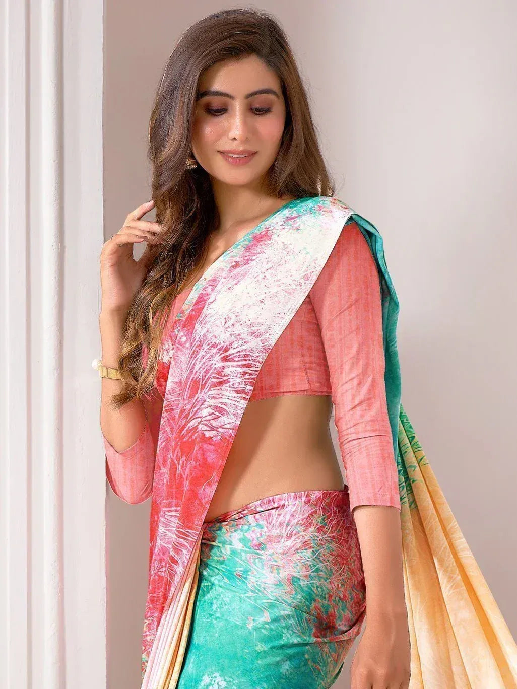 Woman in vibrant printed saree with pink blouse, ethnic Indian wear for festive occasions