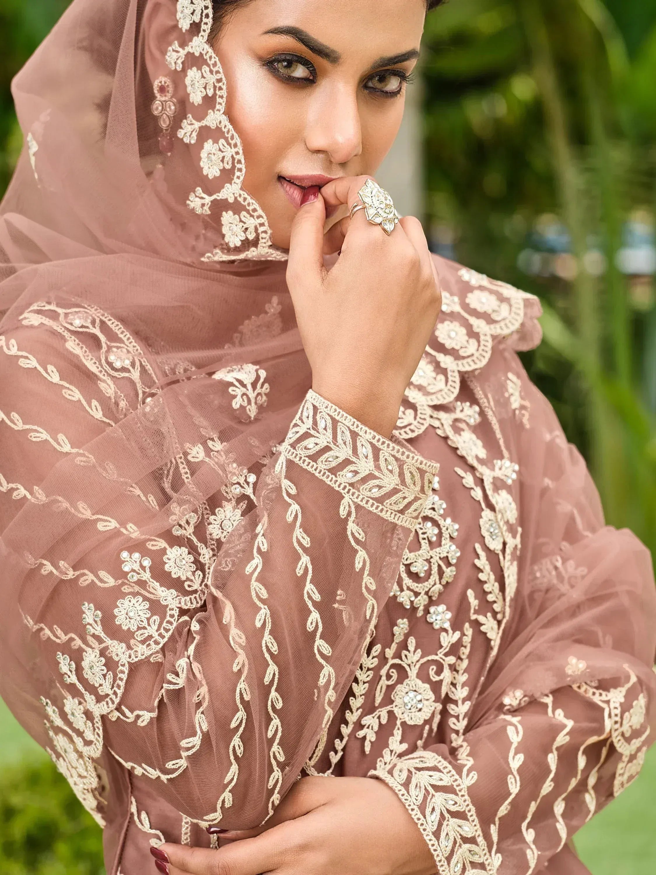 Elegant dusty rose ethnic gown with intricate gold embroidery and floral lace detailing, perfect for festive occasions.