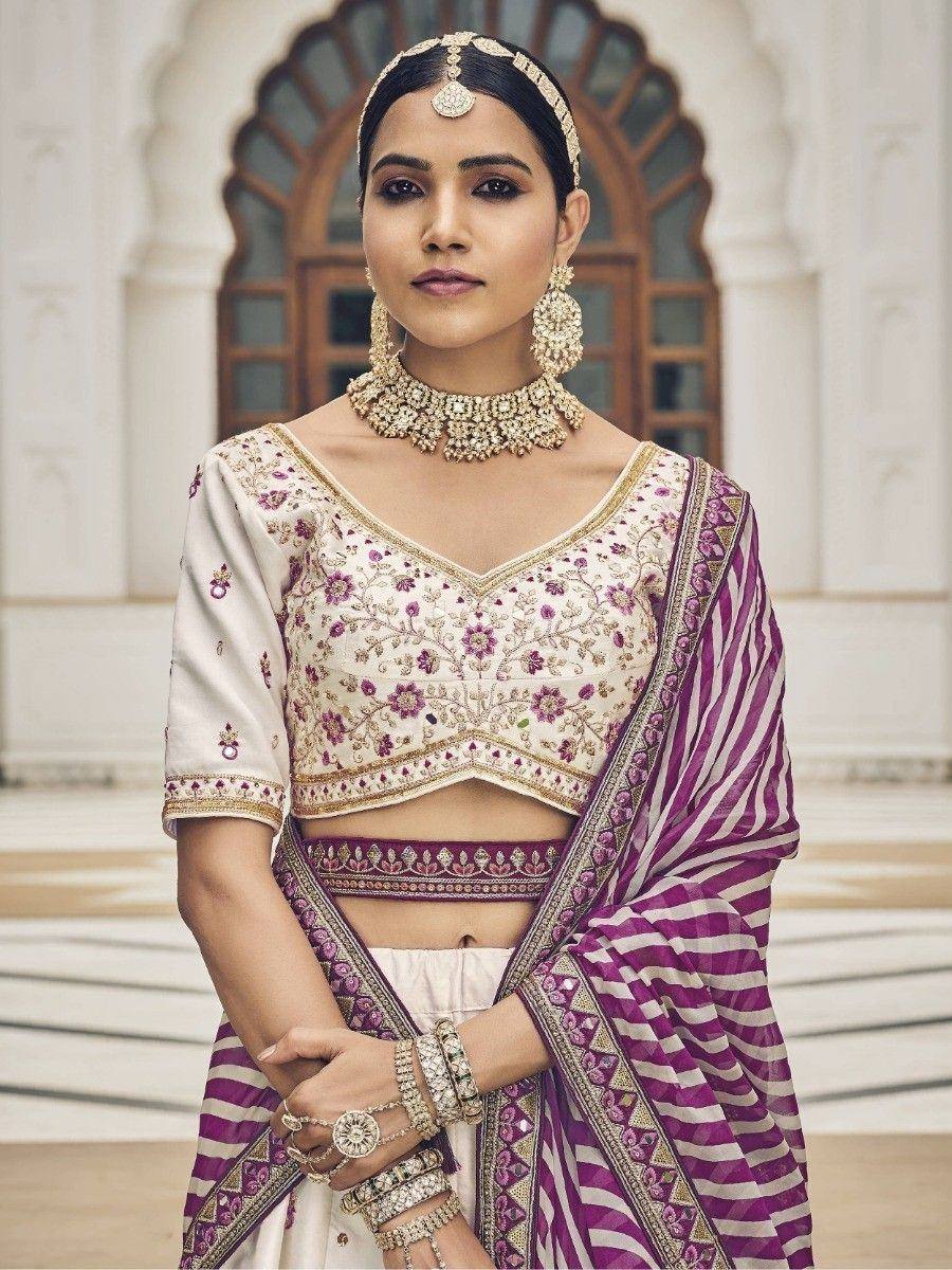 Elegant Indian bridal lehenga choli with purple and white striped dupatta, floral embroidery, and traditional jewelry