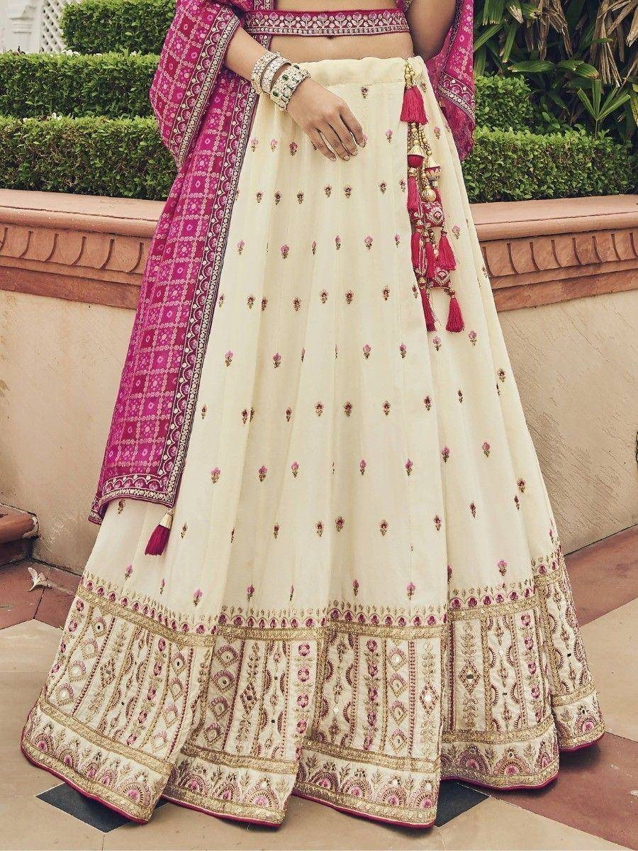 Cream and pink embroidered lehenga choli with tassels, perfect for Indian weddings and festive occasions.