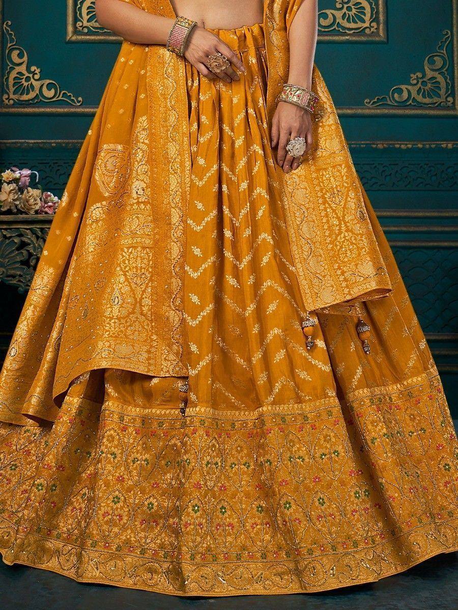 Mustard yellow designer lehenga choli with intricate gold embroidery and floral motifs, perfect for Indian weddings.