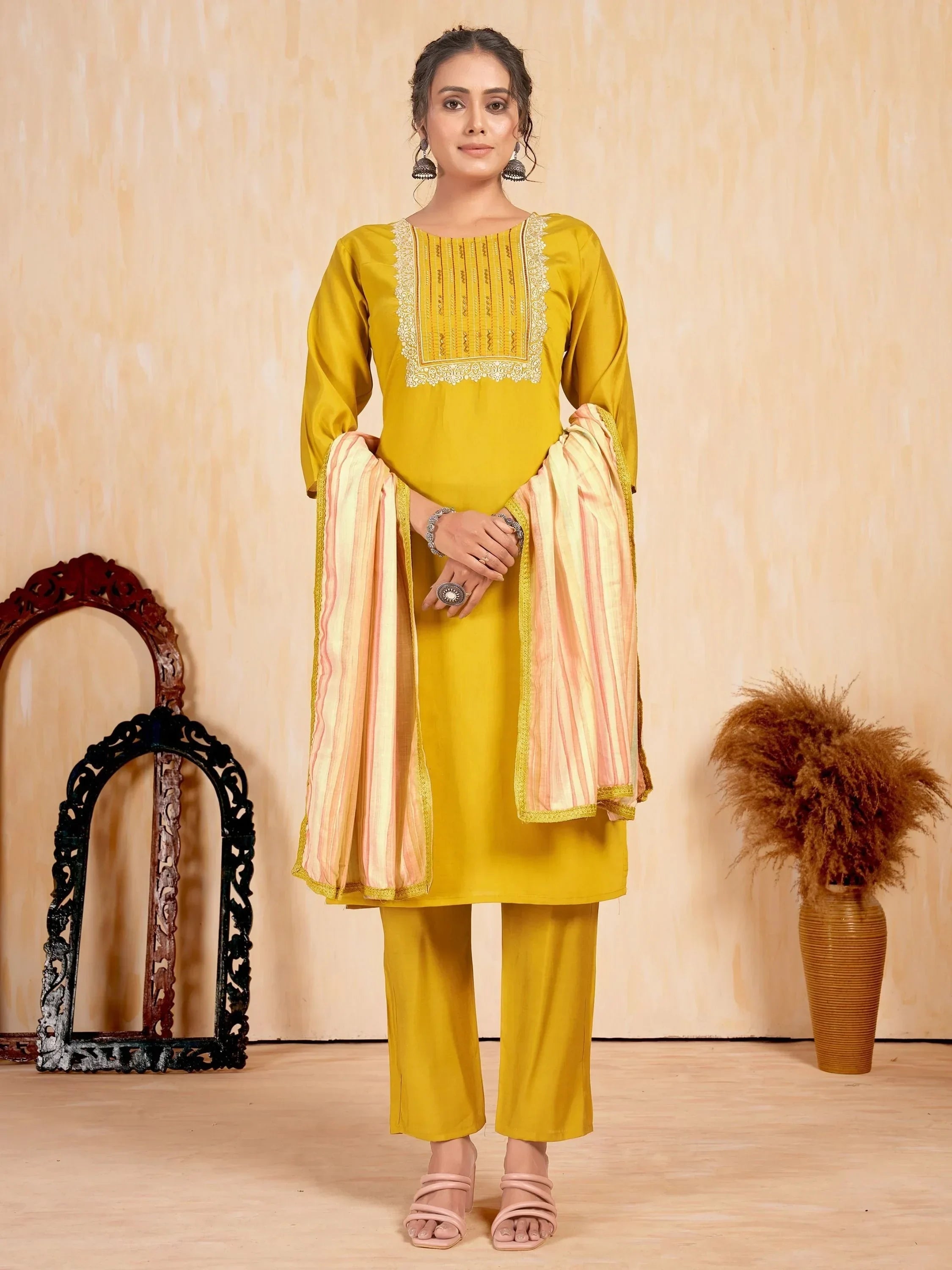 Woman in mustard yellow salwar kameez with embroidered neckline and striped dupatta