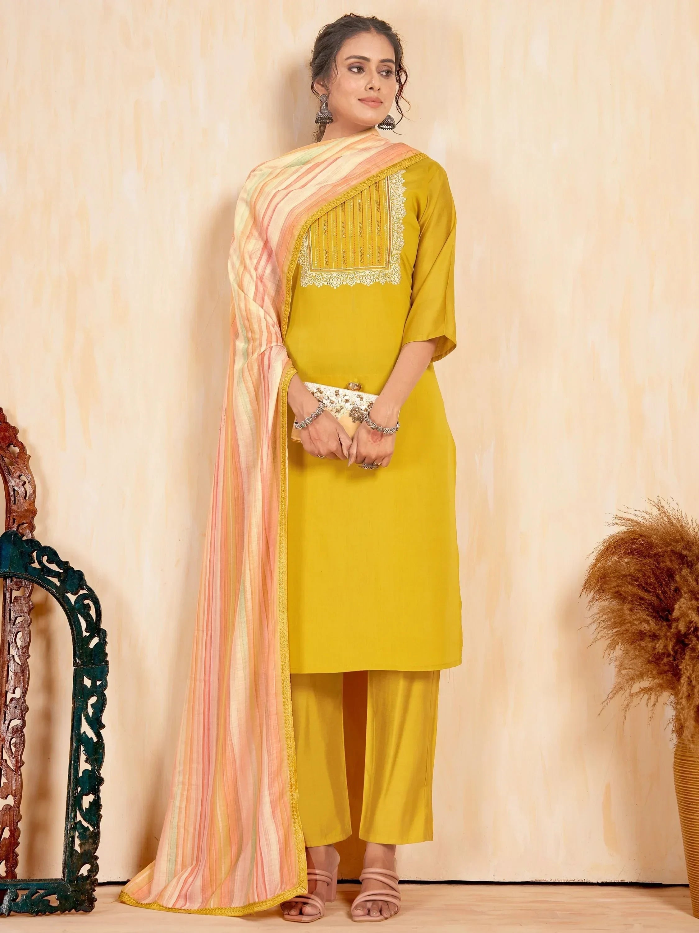 Woman in yellow salwar kameez with striped dupatta and embroidered details