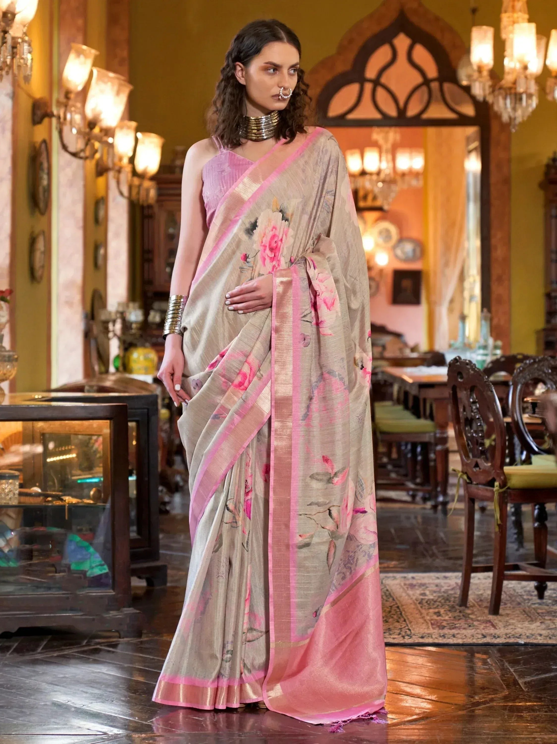 Elegant beige saree with pink floral print and border, paired with matching blouse, perfect for ethnic occasions.