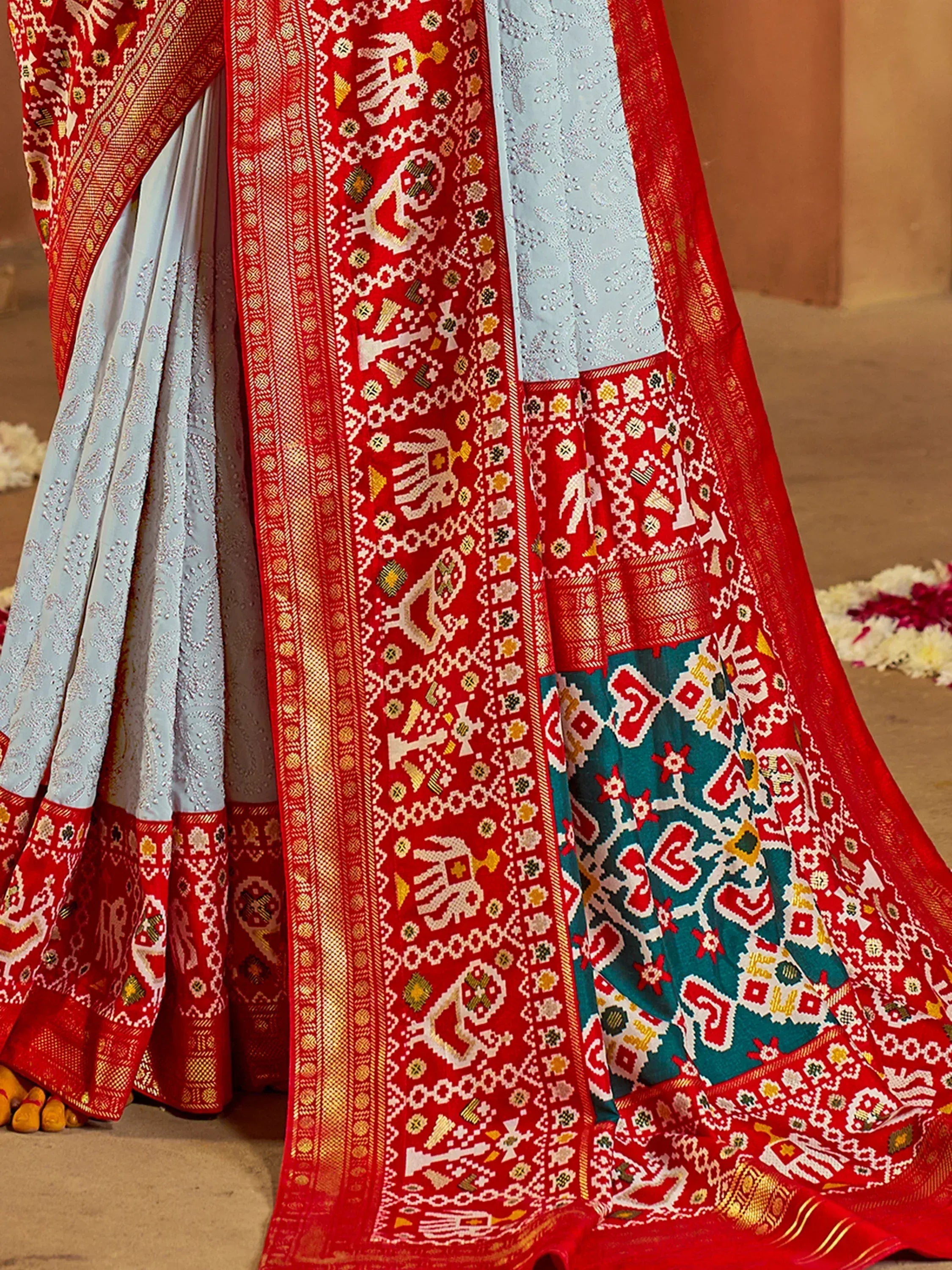Red and blue ethnic saree with intricate elephant and geometric patterns, perfect for Indian weddings and festivals.
