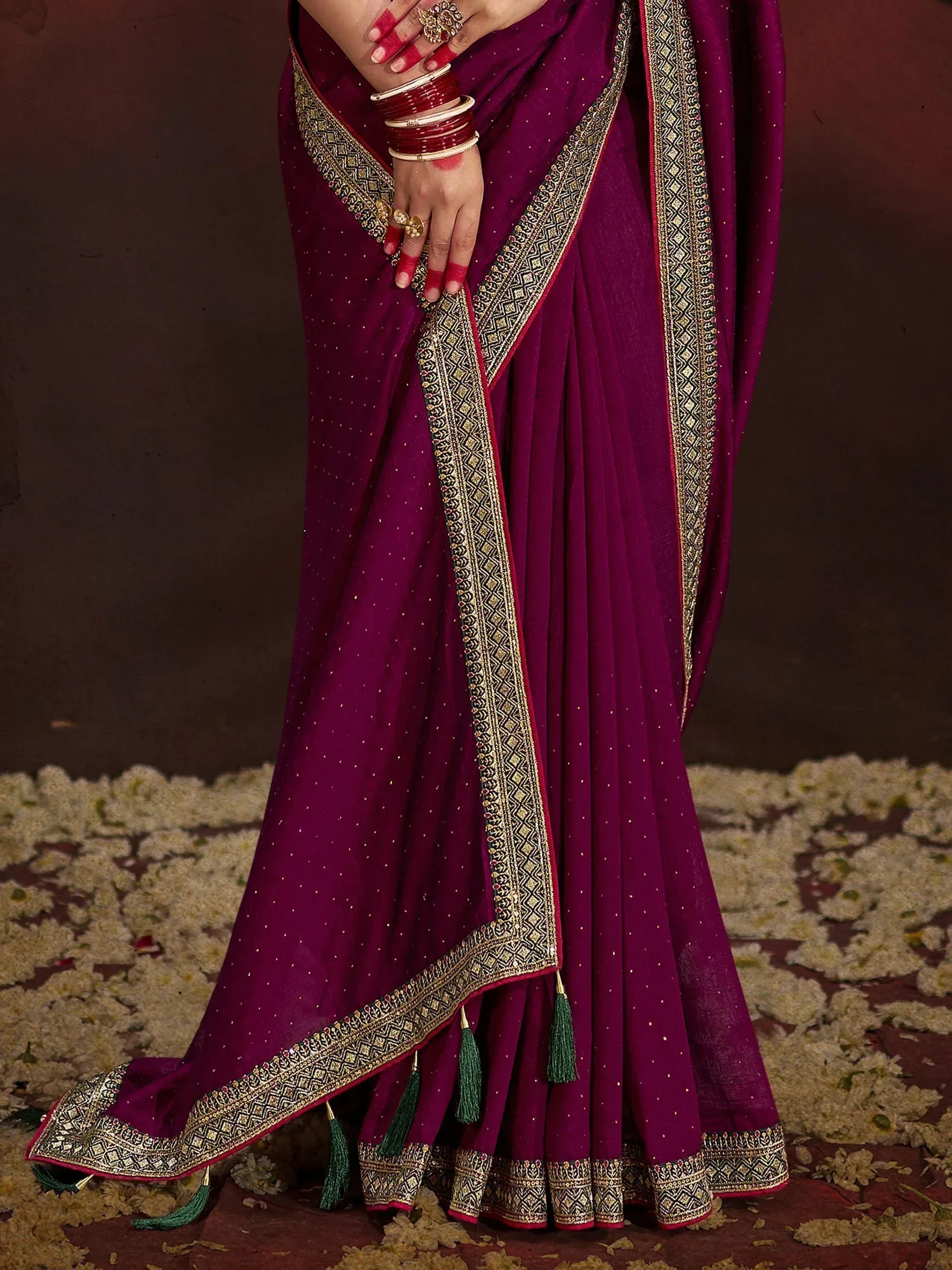 Purple Indian saree with gold border, tassels, and red bangles, perfect for ethnic occasions.